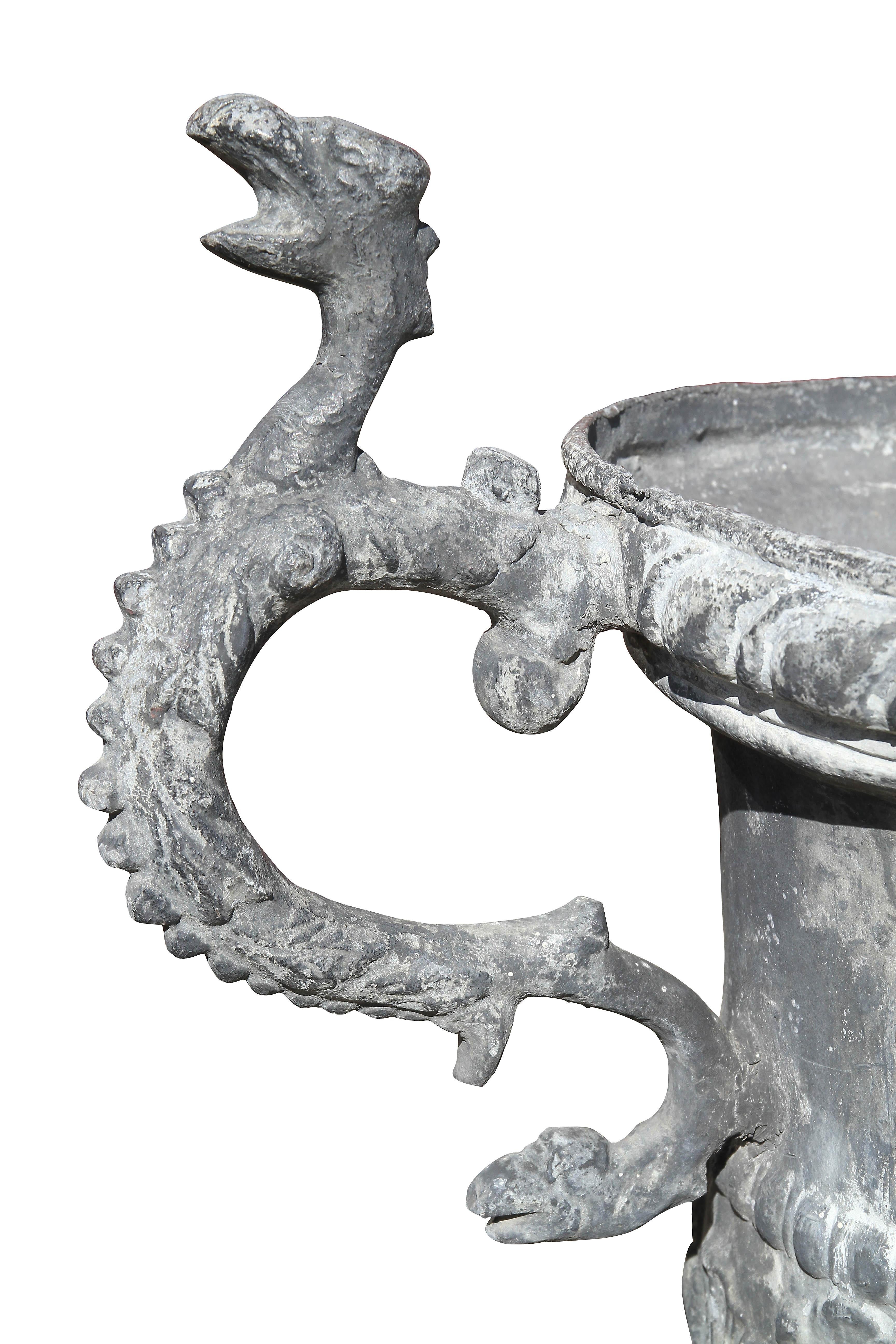 Each circular with gadrooned edge, cherub and leaf decoration, serpent handles, circular egg and dart base.