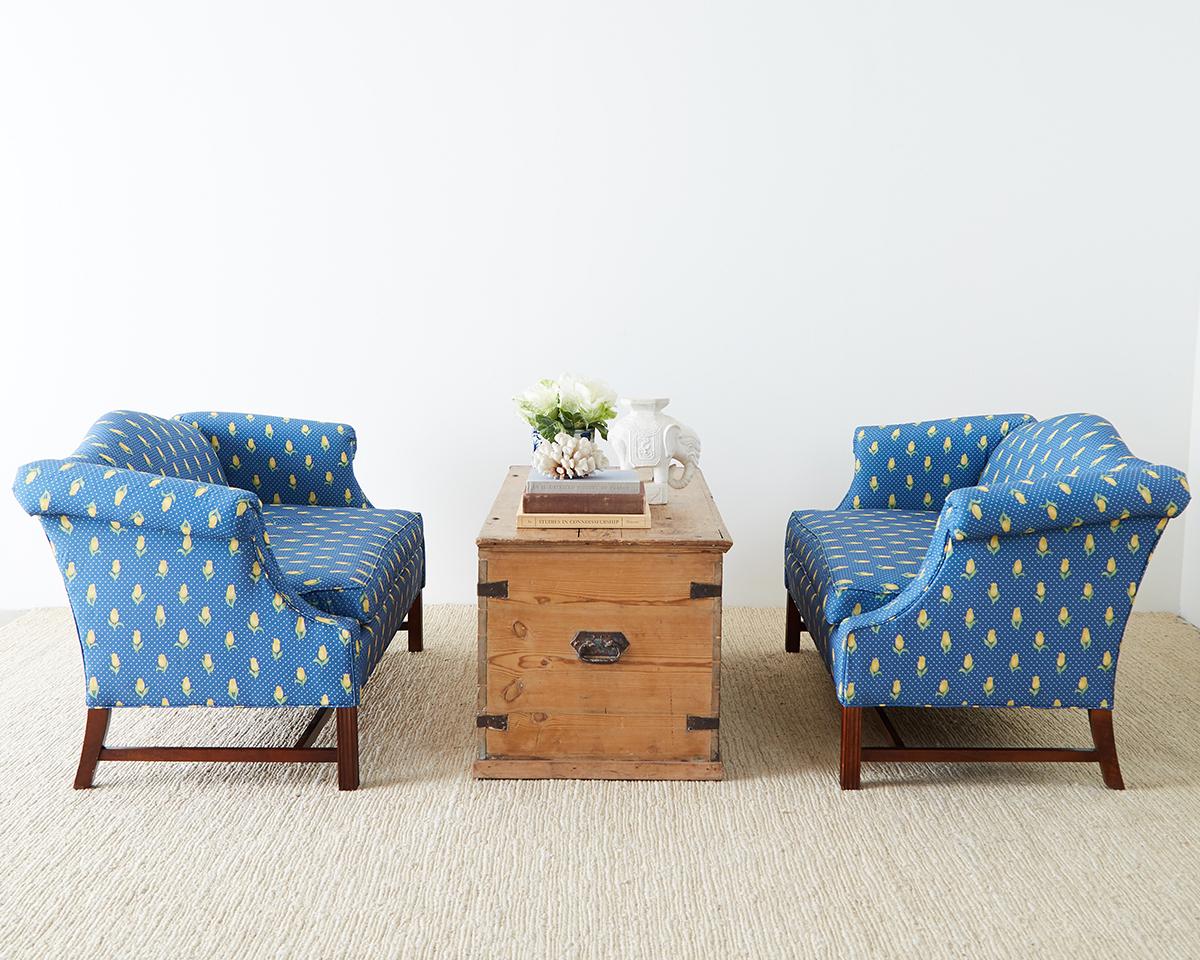 Pleasing pair of mahogany framed camelback settees or love seats made in the George III style. Featuring a yellow tulip motif fabric over a cobalt blue ground. Bespoke pair of settees from the San Francisco Design Center. The mahogany frames made in