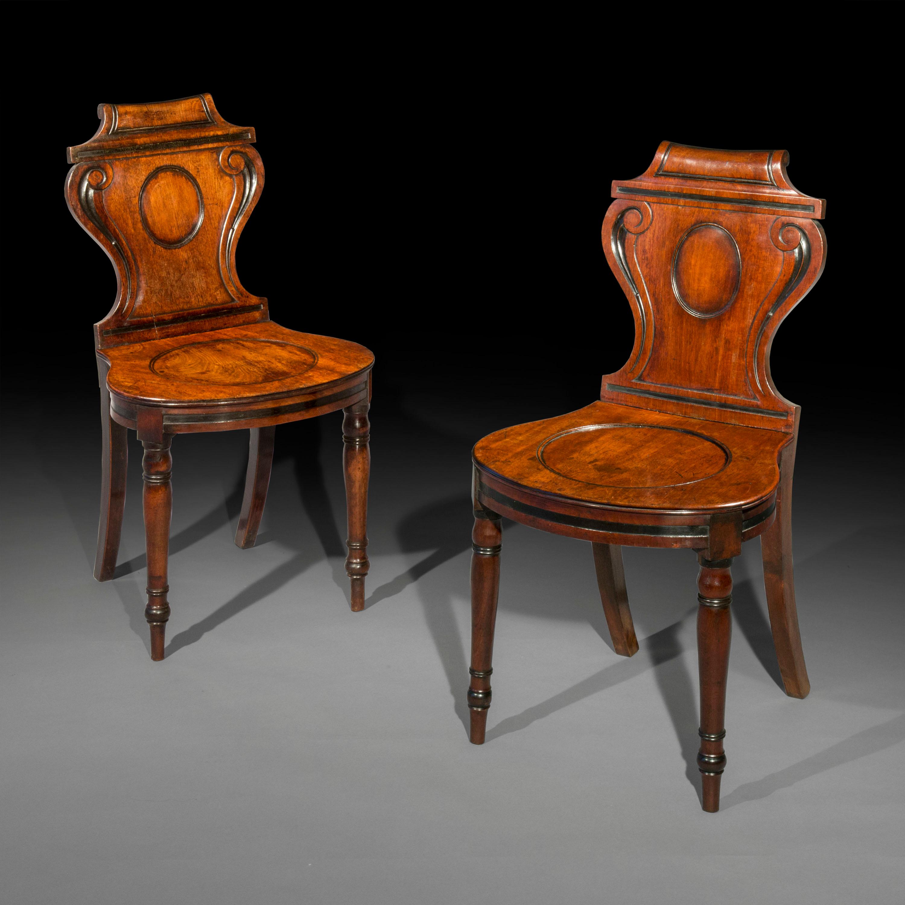 A fine pair of mahogany hall chairs of the Regency period, attributed to Thomas Banting and William France.
England, circa 1815.

Why we like them
These fine hall chairs have a particularly elegant and sophisticated scrolled cartouche design of