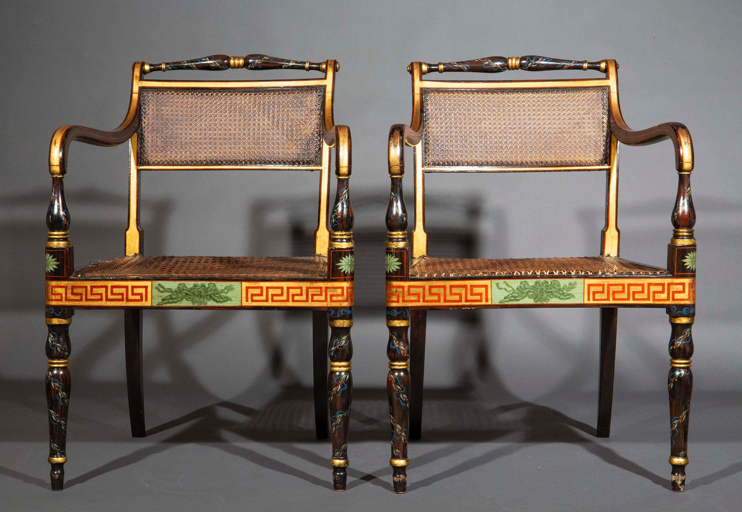A charming pair of painted open armchairs dating back to the English Regency era, exquisitely hand-painted to simulate exotic timber and ornamented with neoclassical festive ribbons and garlands, with Greek key (meander) border to seat rails. THREE