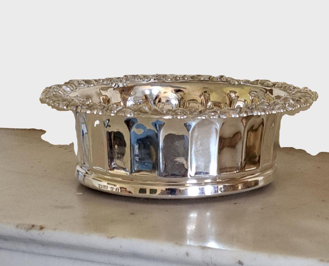 Une amende  Paire de dessous de bouteille en chêne, montés sur argent, de style géorgien .T
 de forme circulaire  avec des bordures de feuillage moulé, un cartouche central représentant une tête de sanglier entre deux plumes, un diamètre de 16,5 cm,