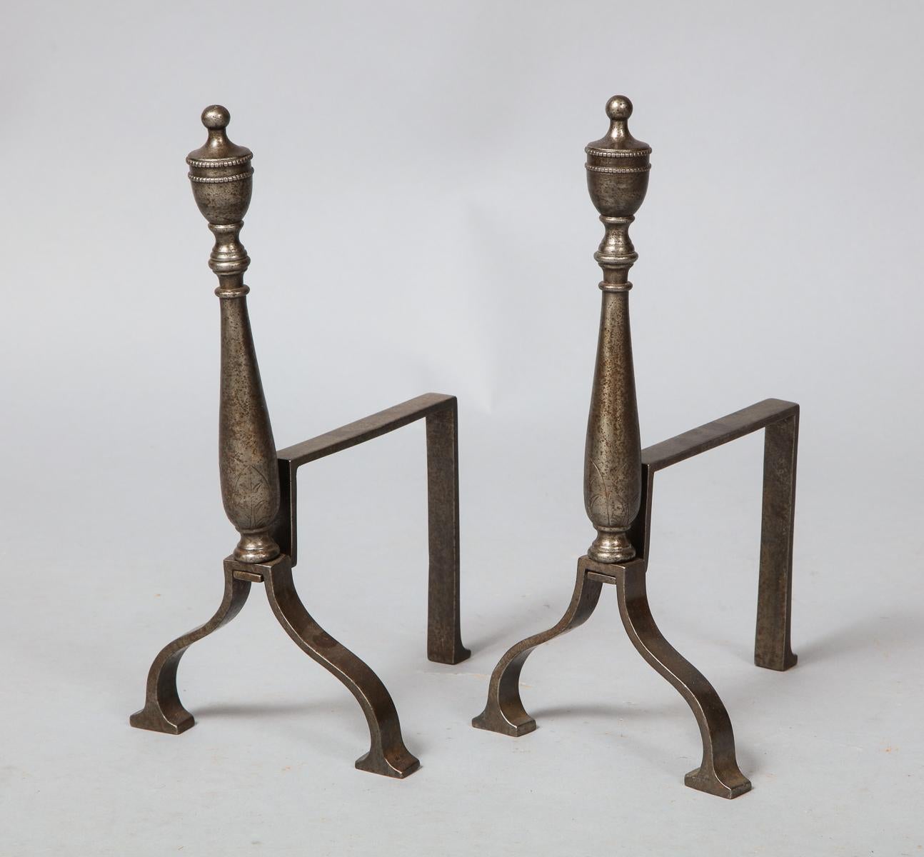 Fine pair of Adam style tool rests, the urn finials and balustrade shafts with etched decoration and standing on ogee legs and square feet. Originally used as rests for fire tools in front of the hearth, these could also serve as andirons in very