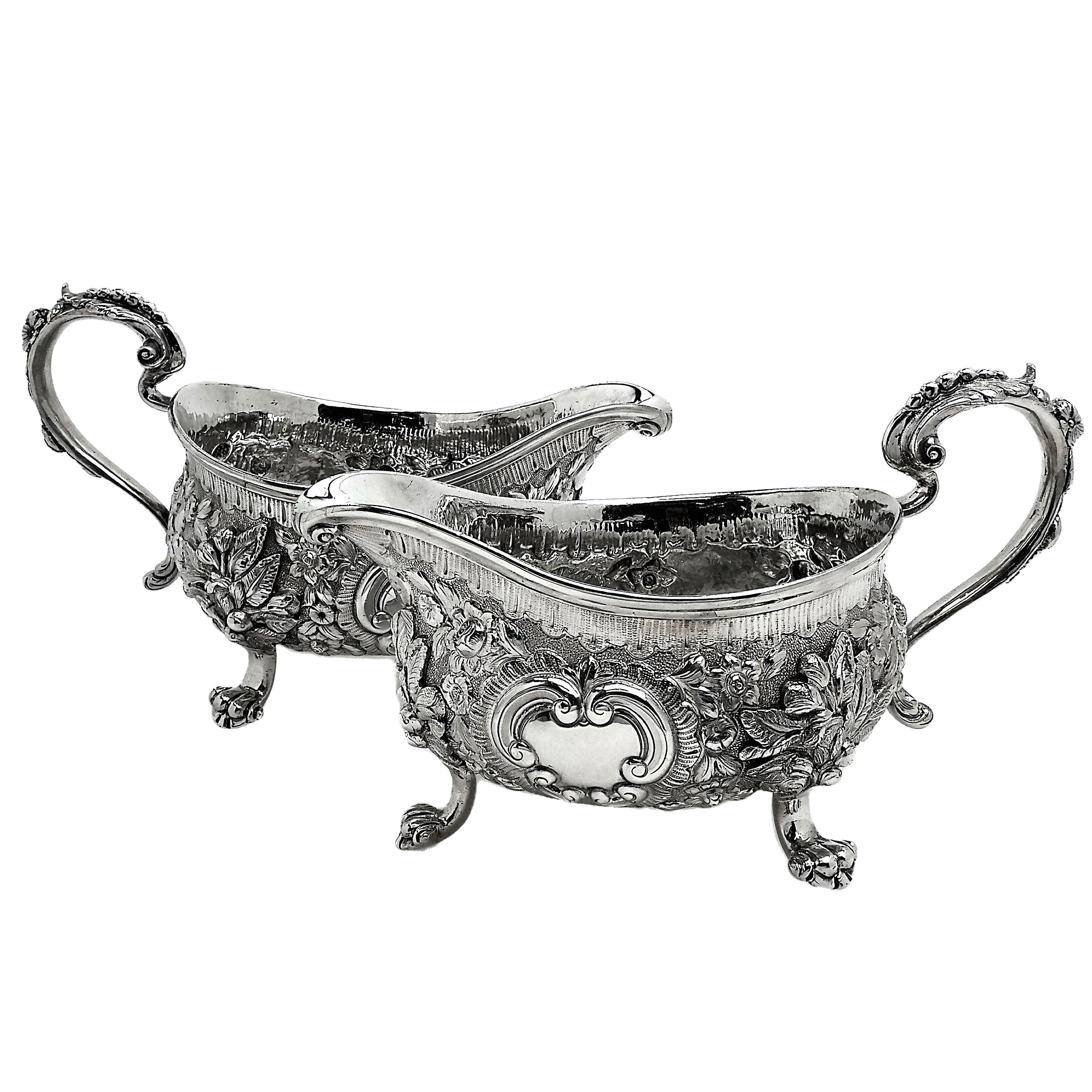 An impressive Pair of Antique Georgian solid Silver Sauce / Gravy Boats. These Gravy Boats are of notably substantial size and weight. Each Sauce Boat is embellished with an ornate chased design incorporating floral and scroll patterns. Each Jug has