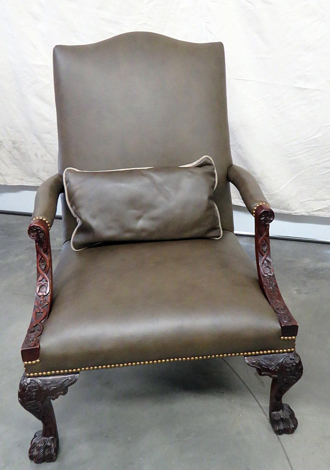 This is a gorgeous pair of Georgian style armchairs with leather upholstery, hairy paw feet, nailhead trim and matching accent pillows. They are in good condition and have beautifully carved frames.