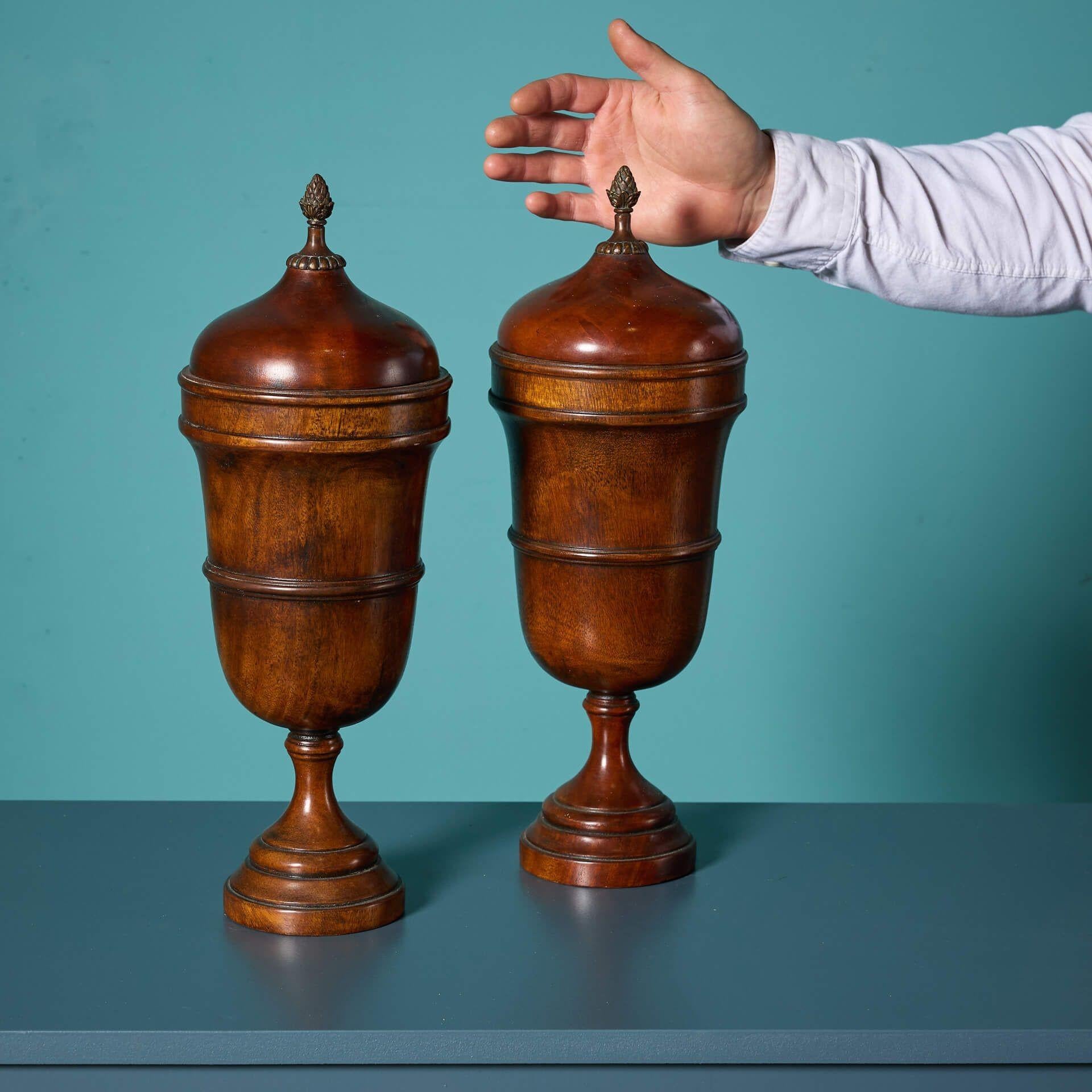 A pair of Georgian style Mahogany lidded urns, from Dunkirk Manor.

The wooden lidded finials on circular turned bases are complimented by acorn shaped tops.

In classical Georgian styling, this striking pair are perfectly balanced and