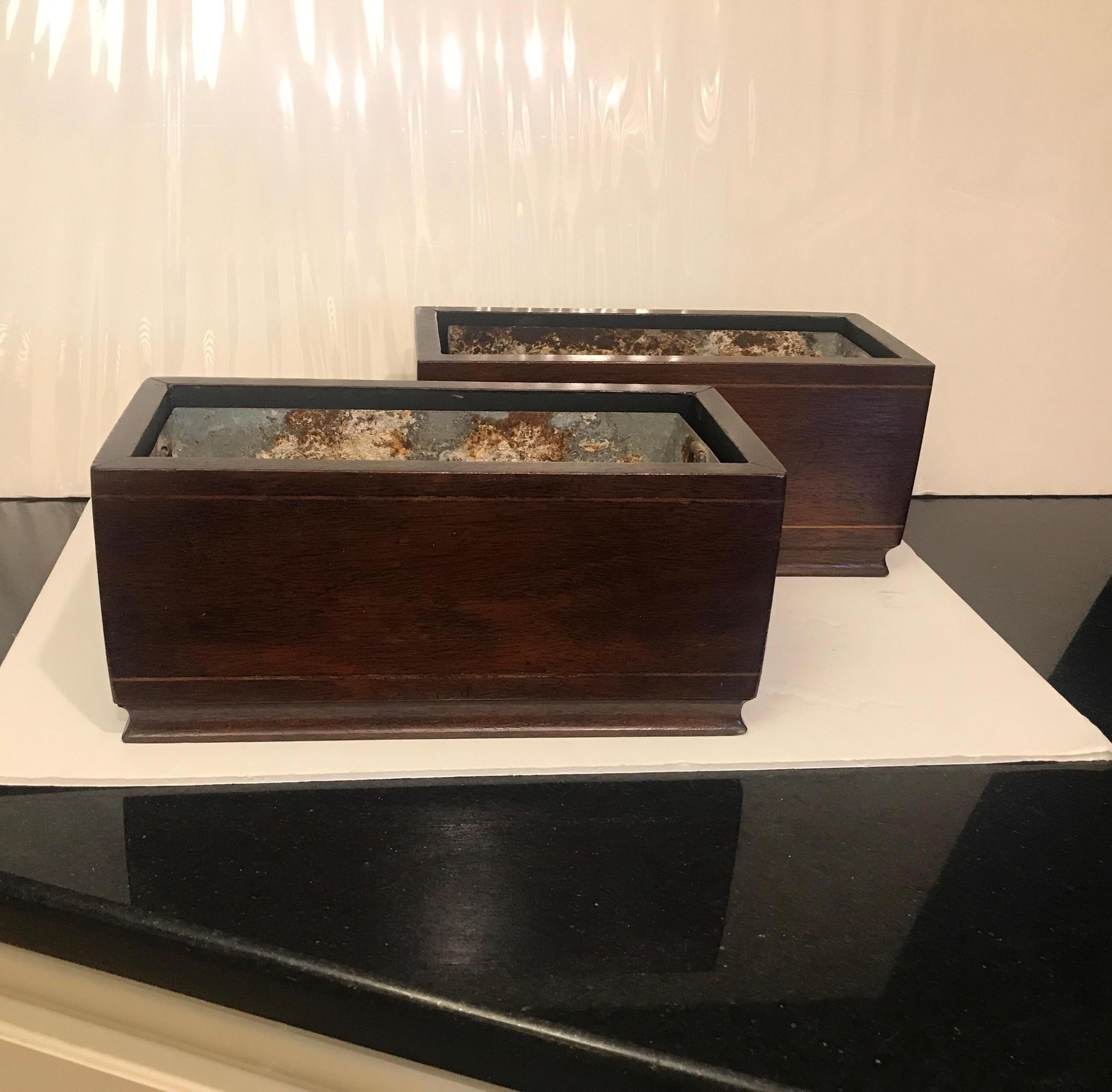 A pair of diminutive Georgian style rich mahogany box planters with original tin liners. The planters are 11 inches long with brass lion and ring handles with tin lines. Functional and beautiful for mantel (fireplace) or console table.