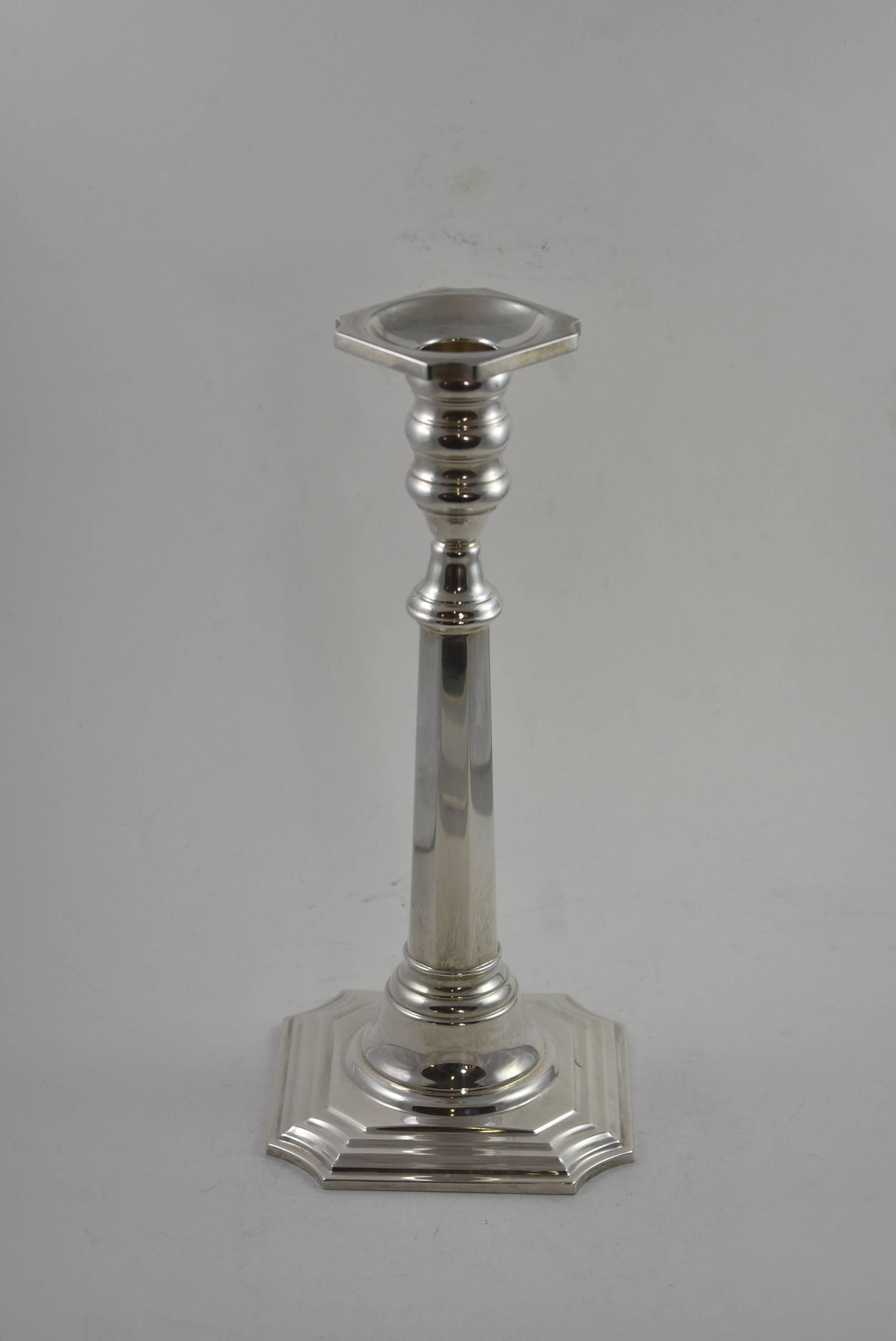 A beautiful pair of sterling silver candlesticks by Cartier. These gorgeous candlesticks feature a stepped base and tapered flat panel stems. Marked Cartier on the base. Very good condition. Dimensions: 4.5