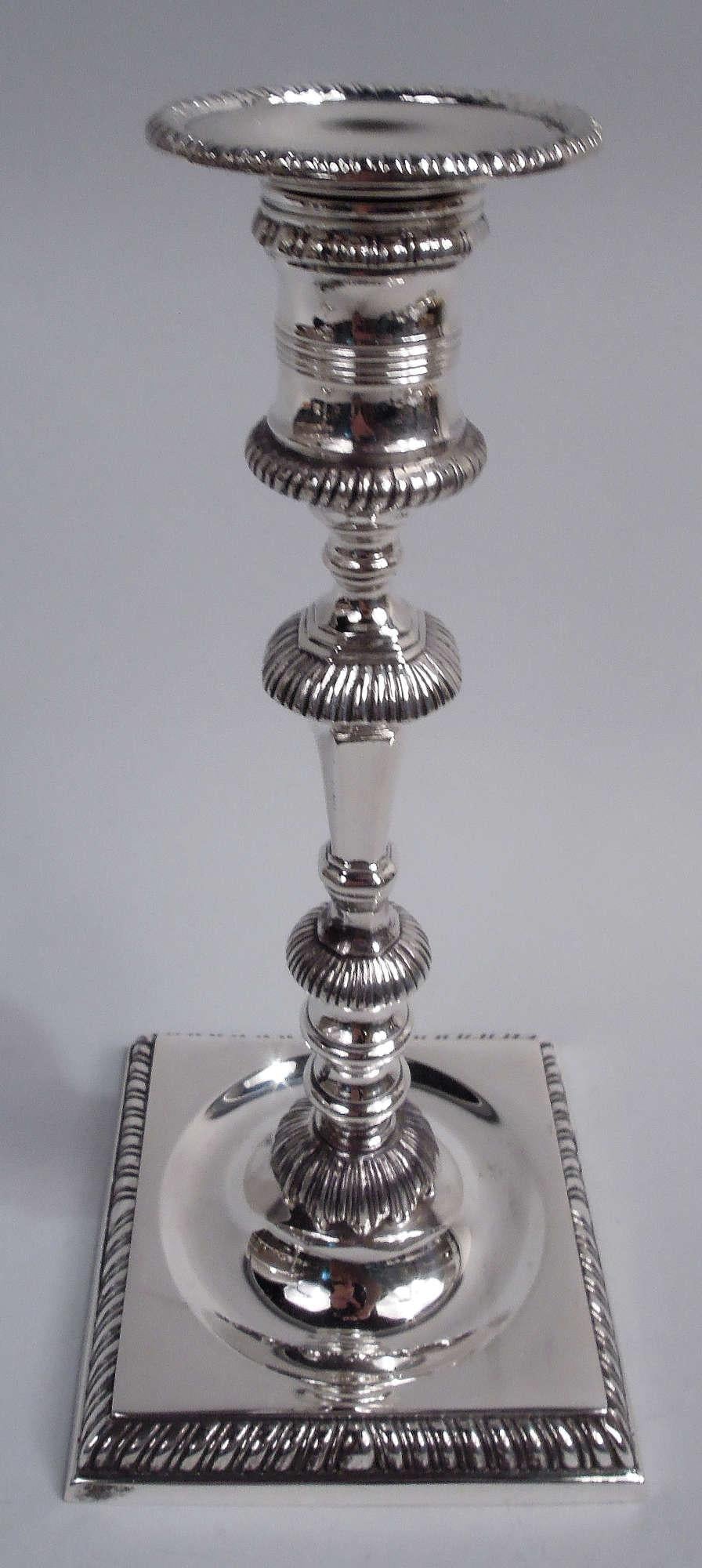 Coppia di candelieri in argento sterling in stile georgiano. Realizzato da Currier & Roby a New York, nel 1920 circa. Ciascuno: Fusto sfaccettato e affusolato con nodi e flange su piede rialzato in cerchio concavo incastonato in una base quadrata.