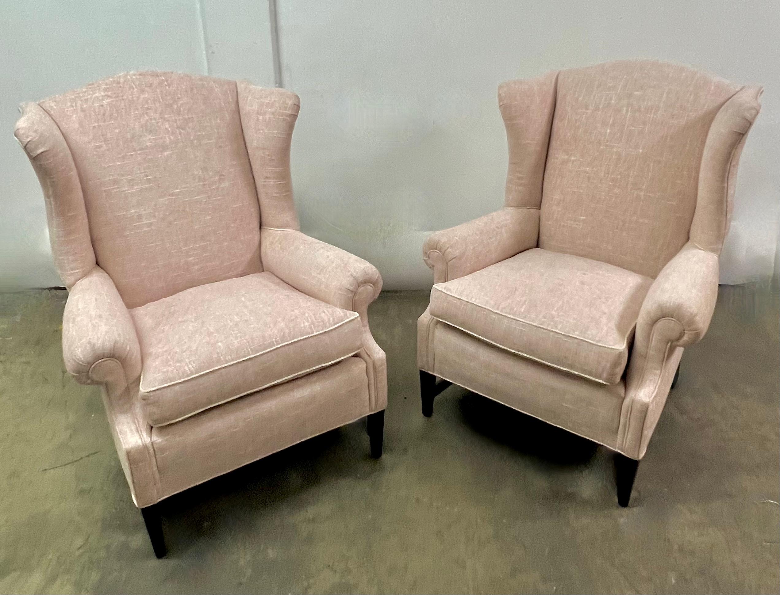 Pair of Wing Back Chairs in the Style of Georgian.  Newly upholstered in Linen with a cord welt to the cushions.  A wonderful pair and very comfortable.  The linen has a pink cast and will work in many spaces.  A nice deep and very attractive wing