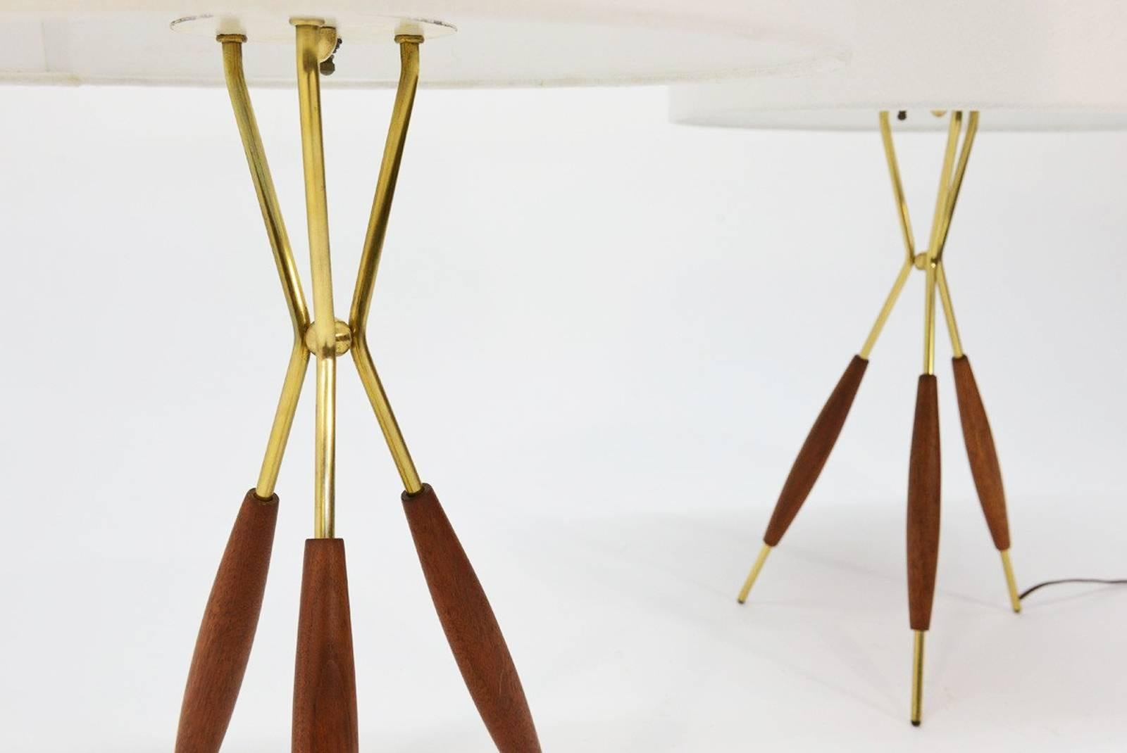 Beautiful pair of walnut and brass tripod table lamps by Gerald Thurston for Lightolier.
Both lamps come with new beige silk shades and original top diffusers. 
Measures: 16? across x 24? tall.