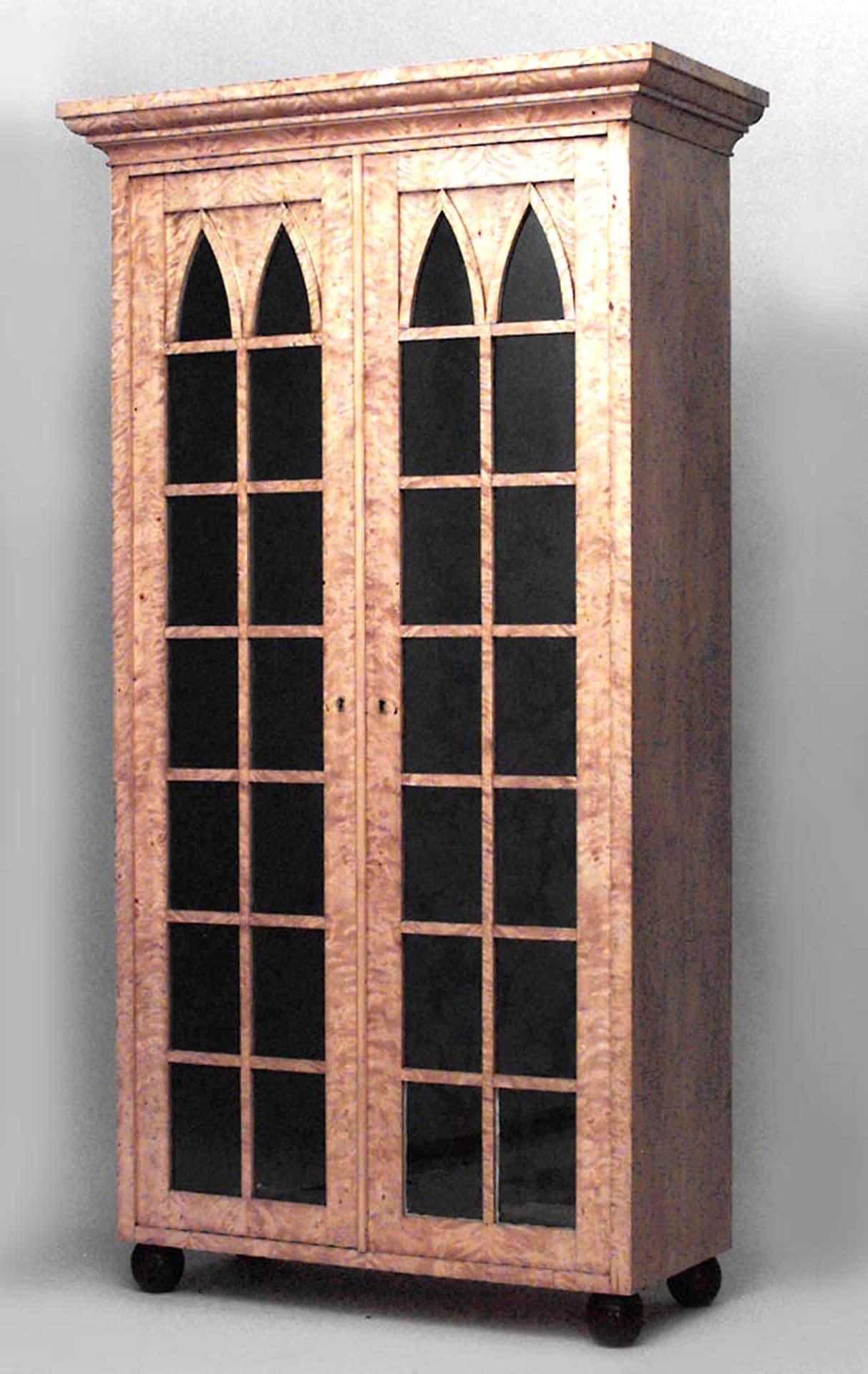 Pair of German Biedermeier (19th Century) flame birch Gothic arch design two-door bookcase cabinets on black lacquered claw feet.
 