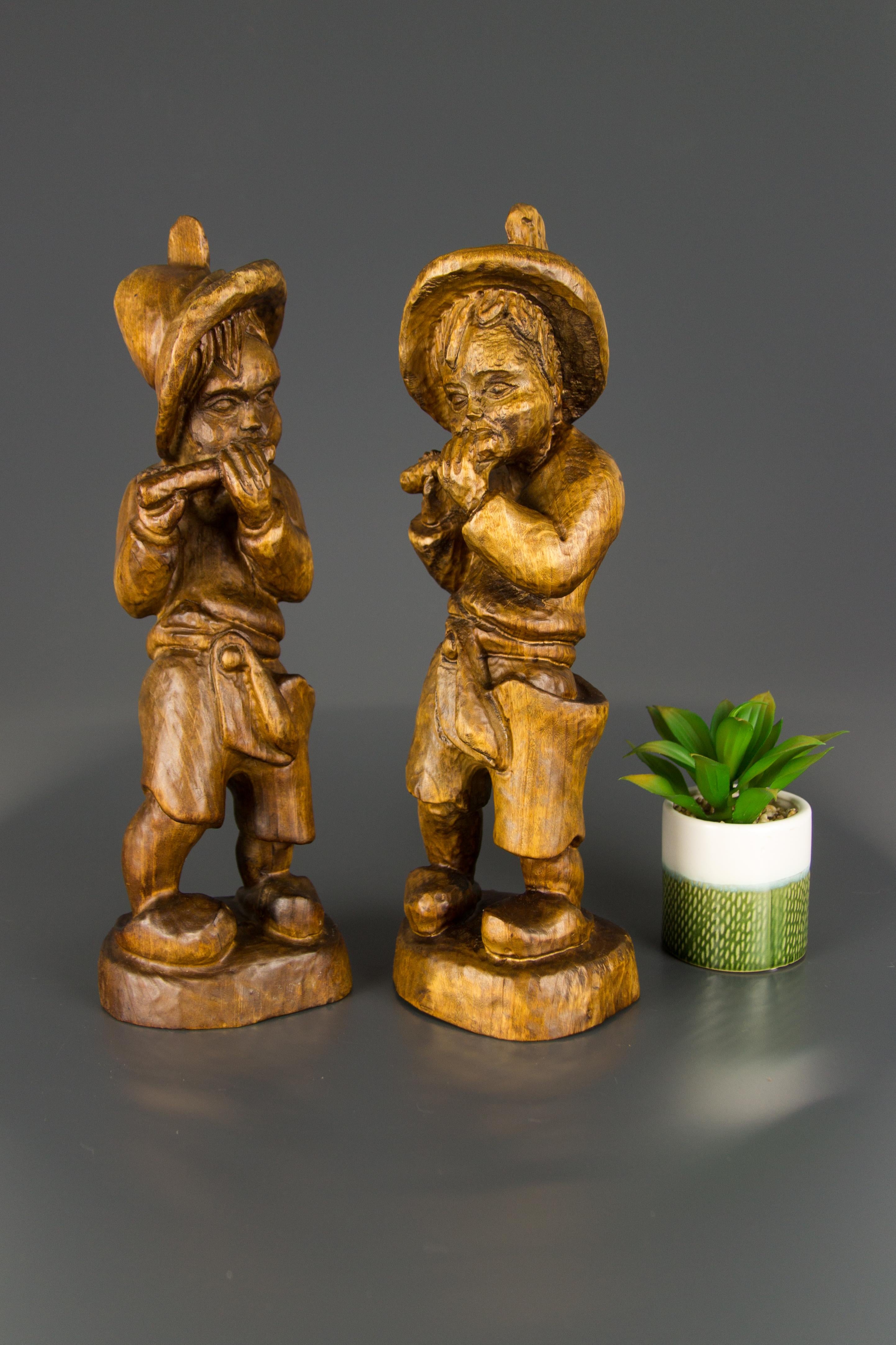 Adorable pair of hand carved wooden figurines of two boys playing the whistle, Germany, the first half of the 20th century.
Dimensions: Height 38 cm / 14.96 in, width circa 12 cm / 4.72 in, depth circa 9 cm / 3.54 in.
   