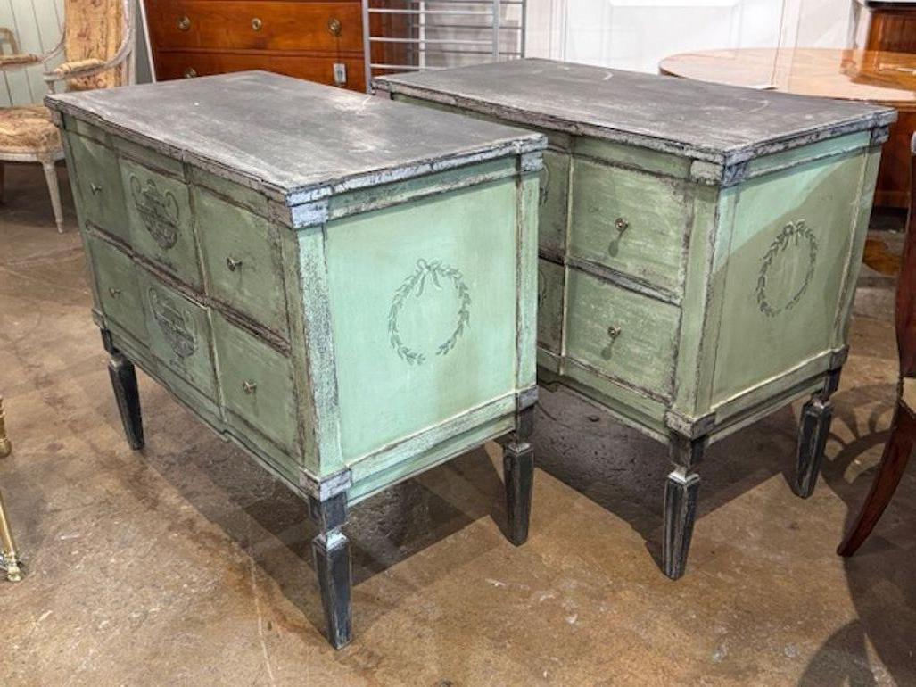 Le produit est une paire de coffres verts peints à la main, de style néo-classique. Ces coffres sont habillés d'une belle couleur vert pâle avec une finition peinte, ce qui leur donne un aspect unique.  Fabriqués en Allemagne, ces coffres témoignent