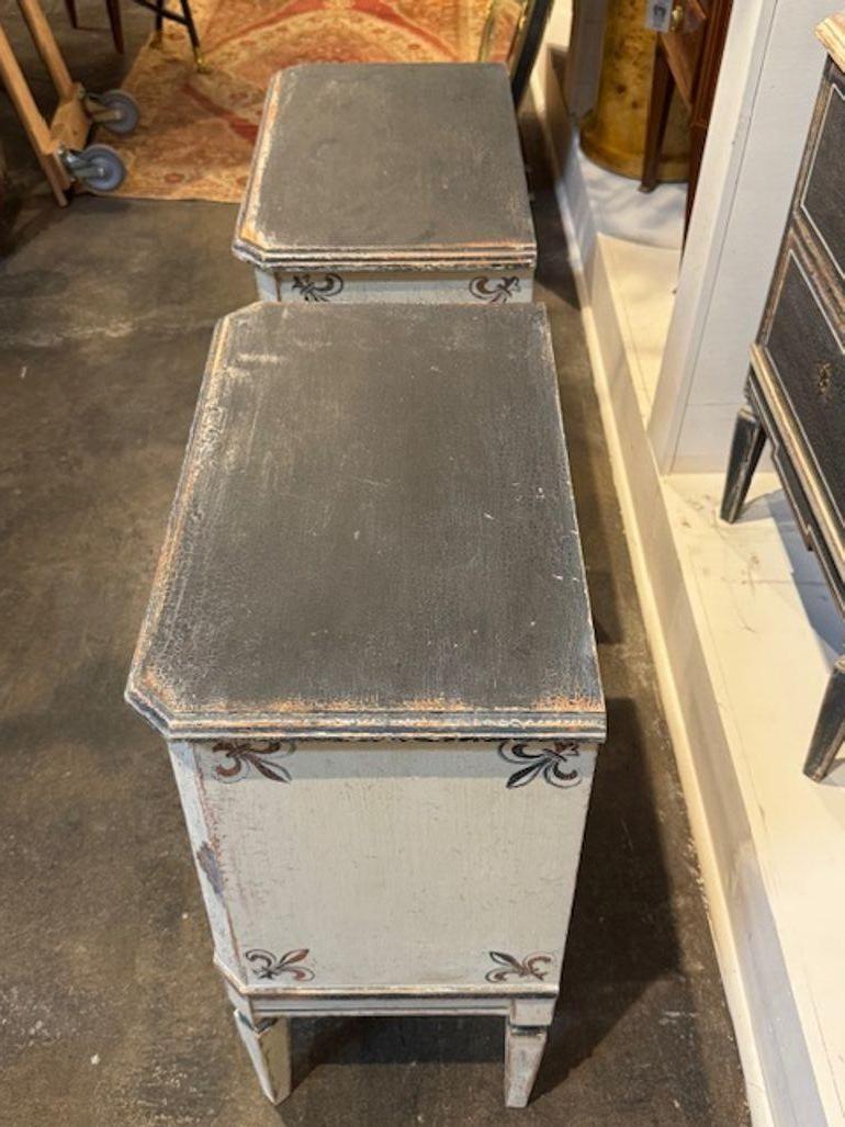 Ce produit est une paire de tables de chevet néoclassiques allemandes peintes à la main. Le style néoclassique classique ajoute une touche de luxe à n'importe quelle pièce, tandis que les détails peints à la main font de chaque table une pièce