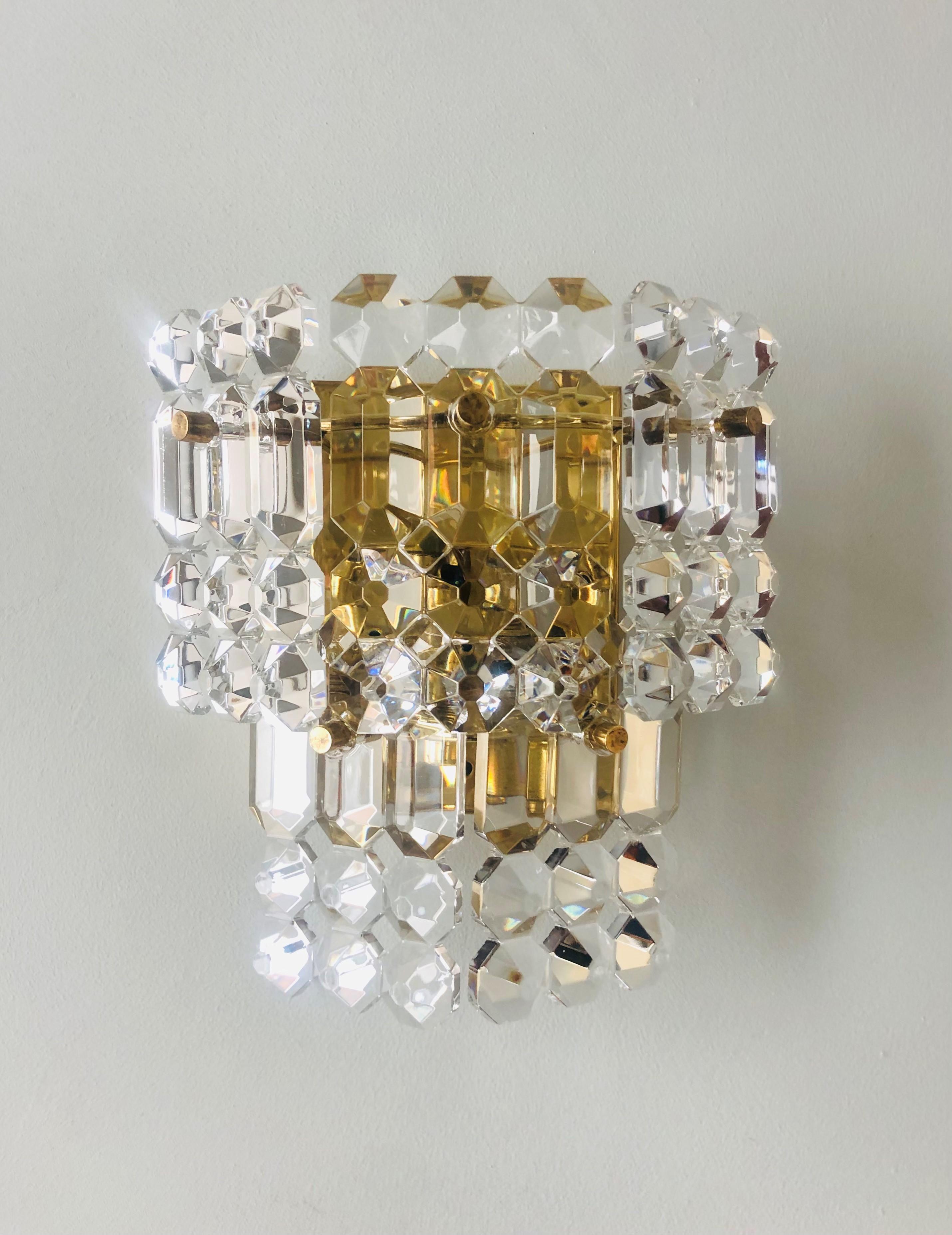 Lovey and stunning Mid-century Pair of crystal Wall Sconces. These Wall Sconces were manufactured during the 1970s in Germany by Kinkeldey. Each Wall Sconce is composed by five crystals and brass structure. A professional electrician has checked and