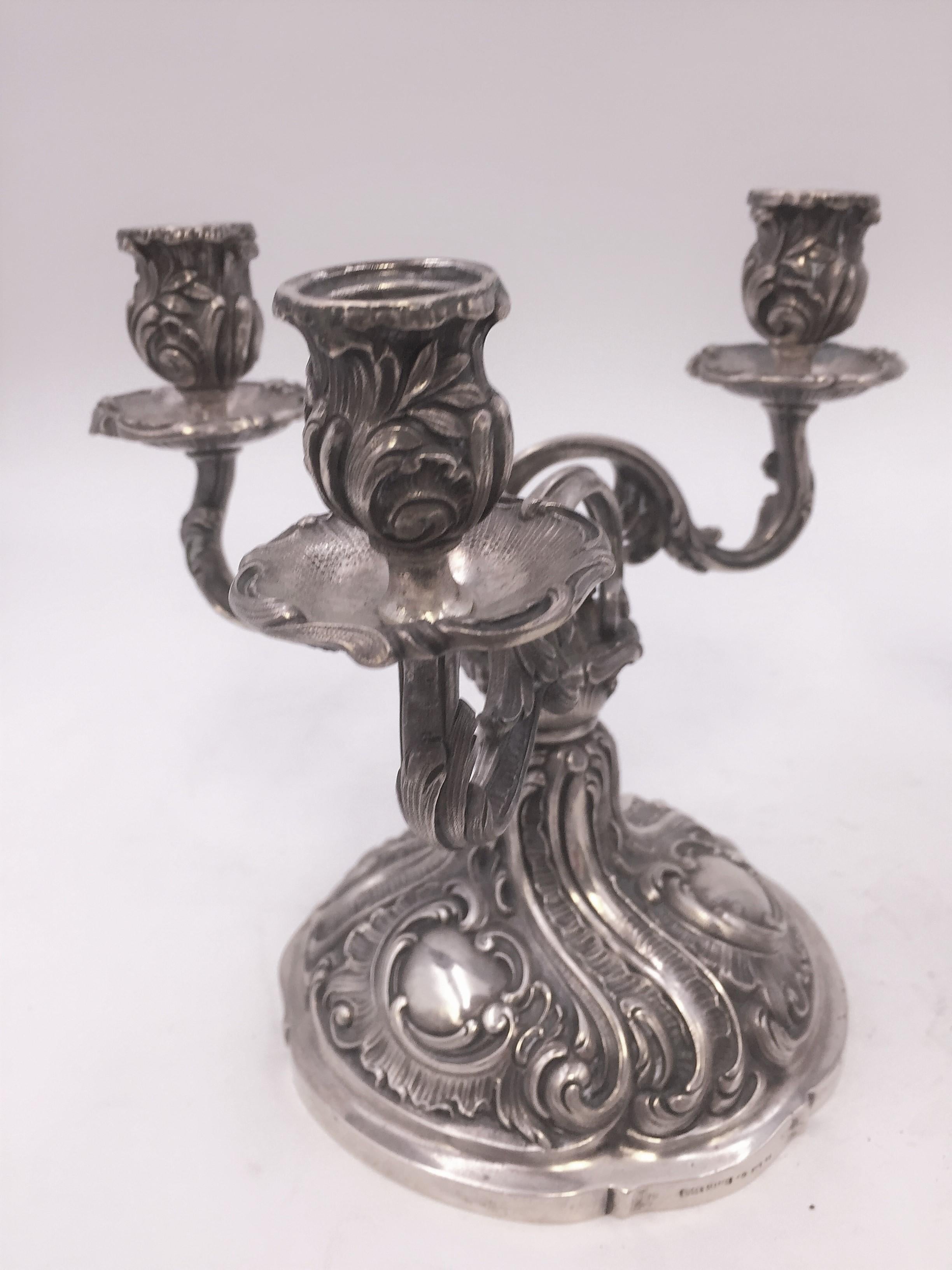 Pair of German 800 silver candelabra by Eugene Marcus, designed with raised foliage on the bobeches and on the base, three dimensional foliage on the stems of the candelabra. Measuring approximately 7 inches tall and 7 1/2 inches wide. Weighing
