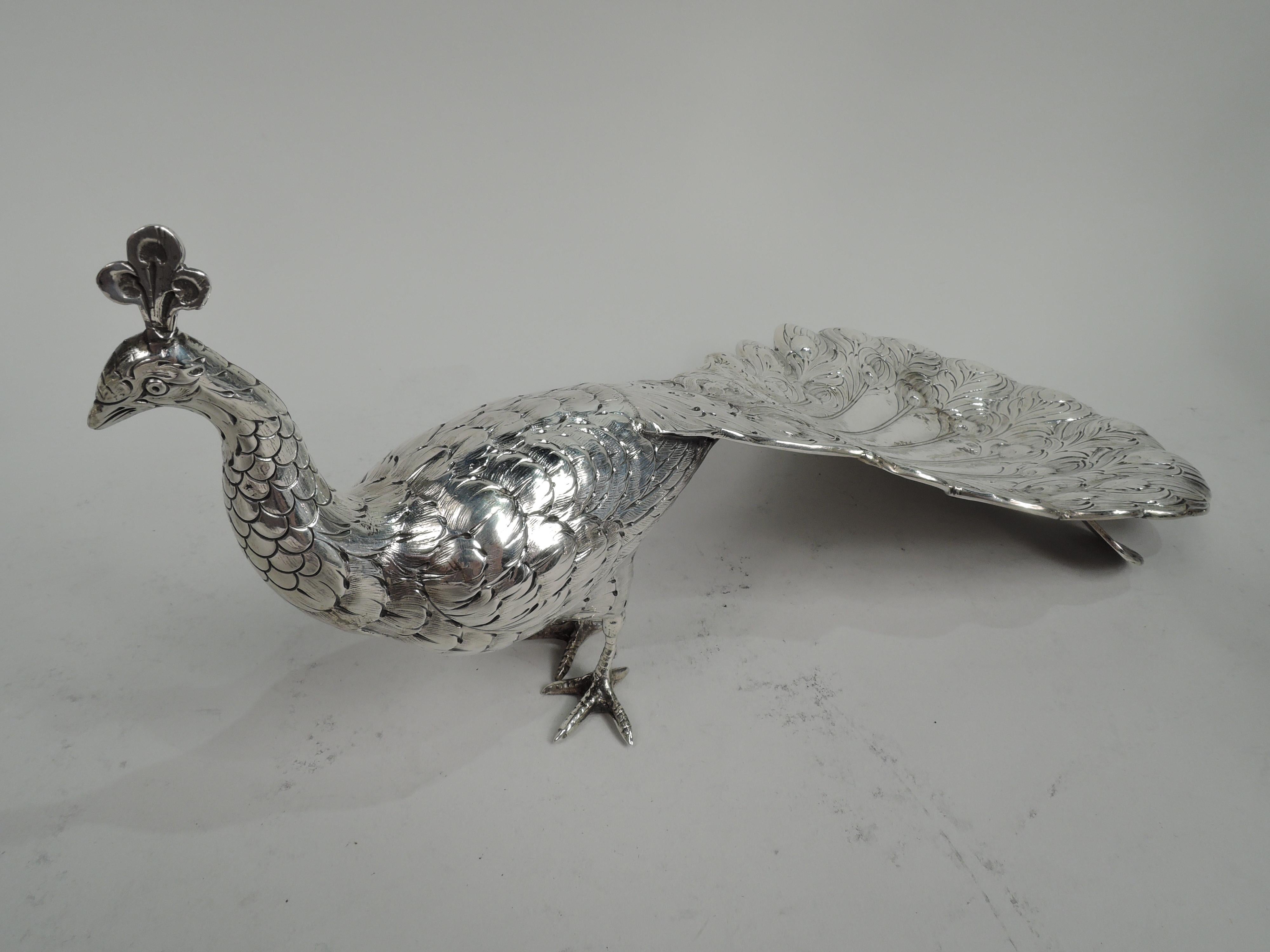 Pair of German 800 silver peacocks, ca 1910. Each: Upright neck and small graceful head supporting a foppish crest. Scaly talons. Ovoid body with dense imbricated feathers and dramatic tail downed and concave for holding treats. Gorgeous but aloof