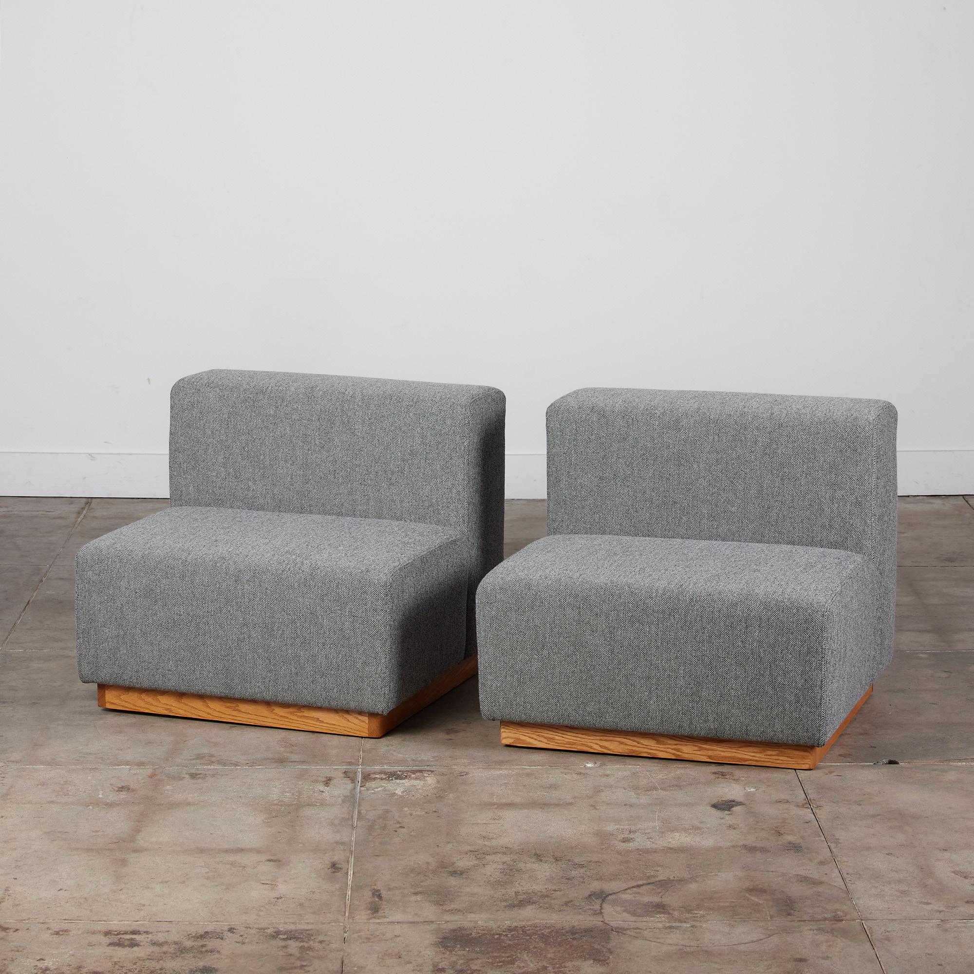 Ein Paar moderne kubische Sofas im Stil von Giancarlo Piretti. Diese Sitze wurden neu mit Kvadrat-Stoff bezogen und bestehen aus zwei modularen Sitzen mit klaren geometrischen Linien. Die Sitze stehen auf einem Sockel aus Eichenholz. Diese