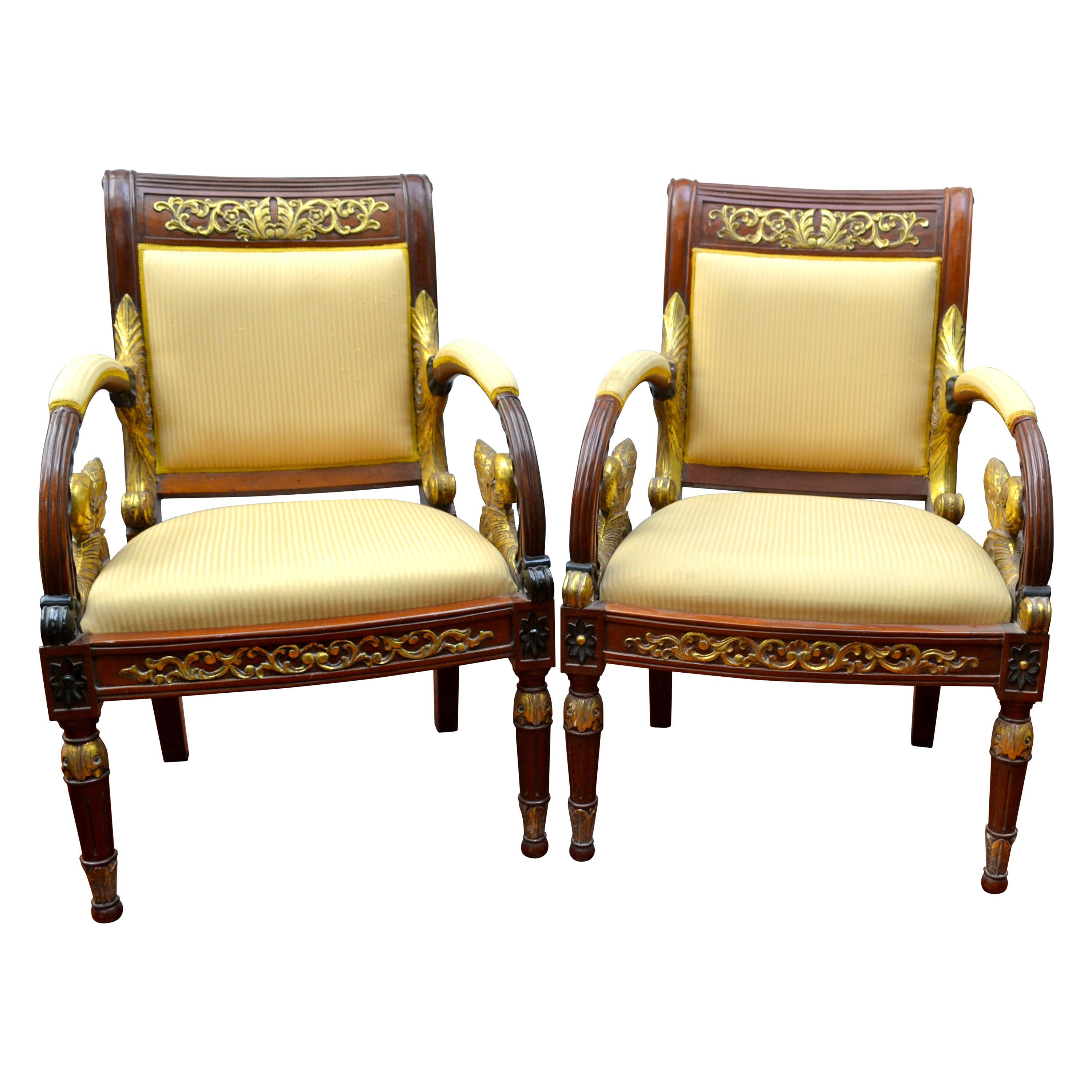 Une paire rare d'élégants et uniques fauteuils en acajou et dorés conçus par Gianni Versace, faisant partie de la collection de meubles Vanitas de 1994. Les pieds avant sont en forme de colonne et s'effilent jusqu'au sol. Les pieds arrière sont