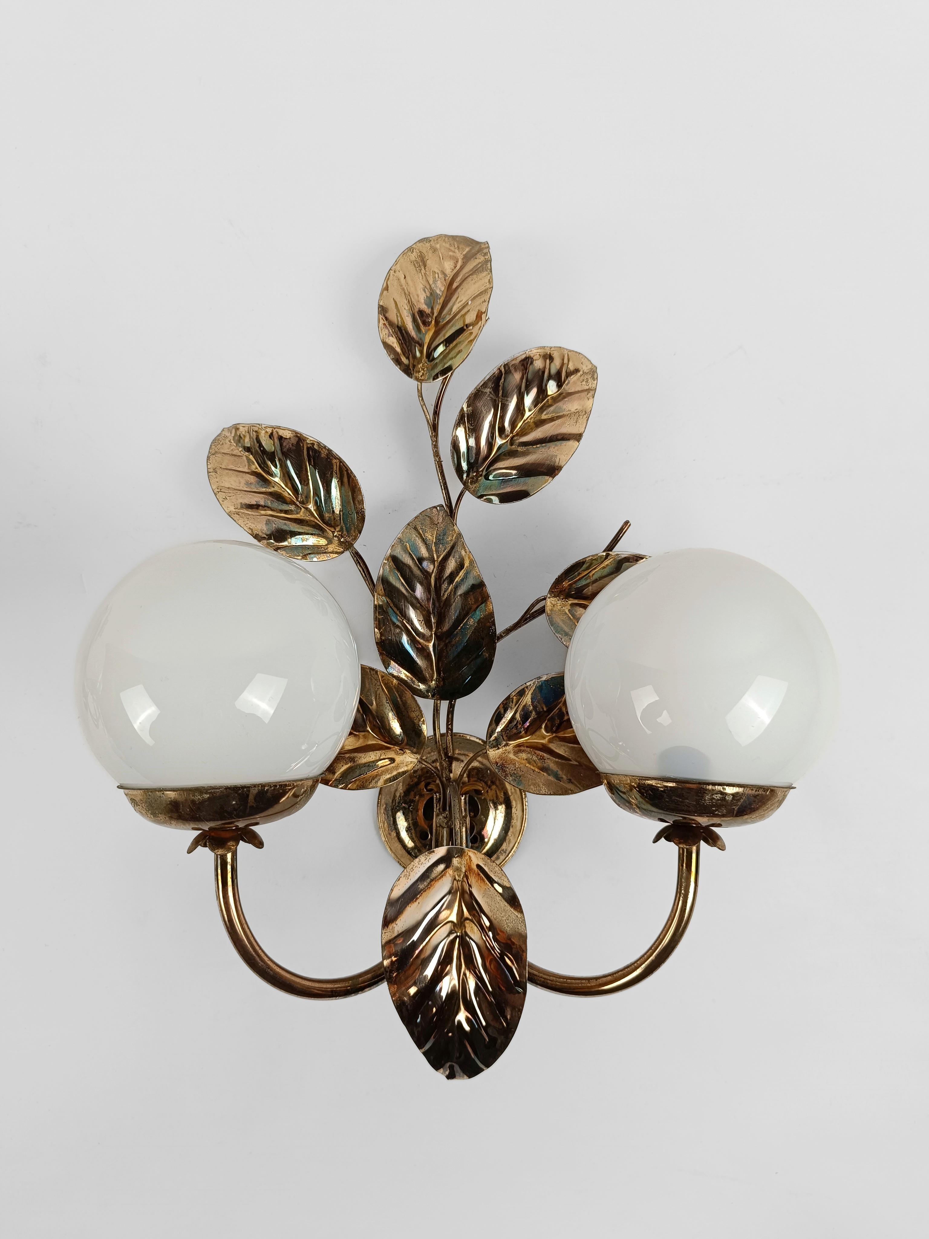 A pair of vintage wall lights made in Italy between the 60s and 70s, elegant and very decorative with their leaf motif that climbs the wall like a pothos plant.

The leafy and gilded decorative element had great success during the 70s, designers and