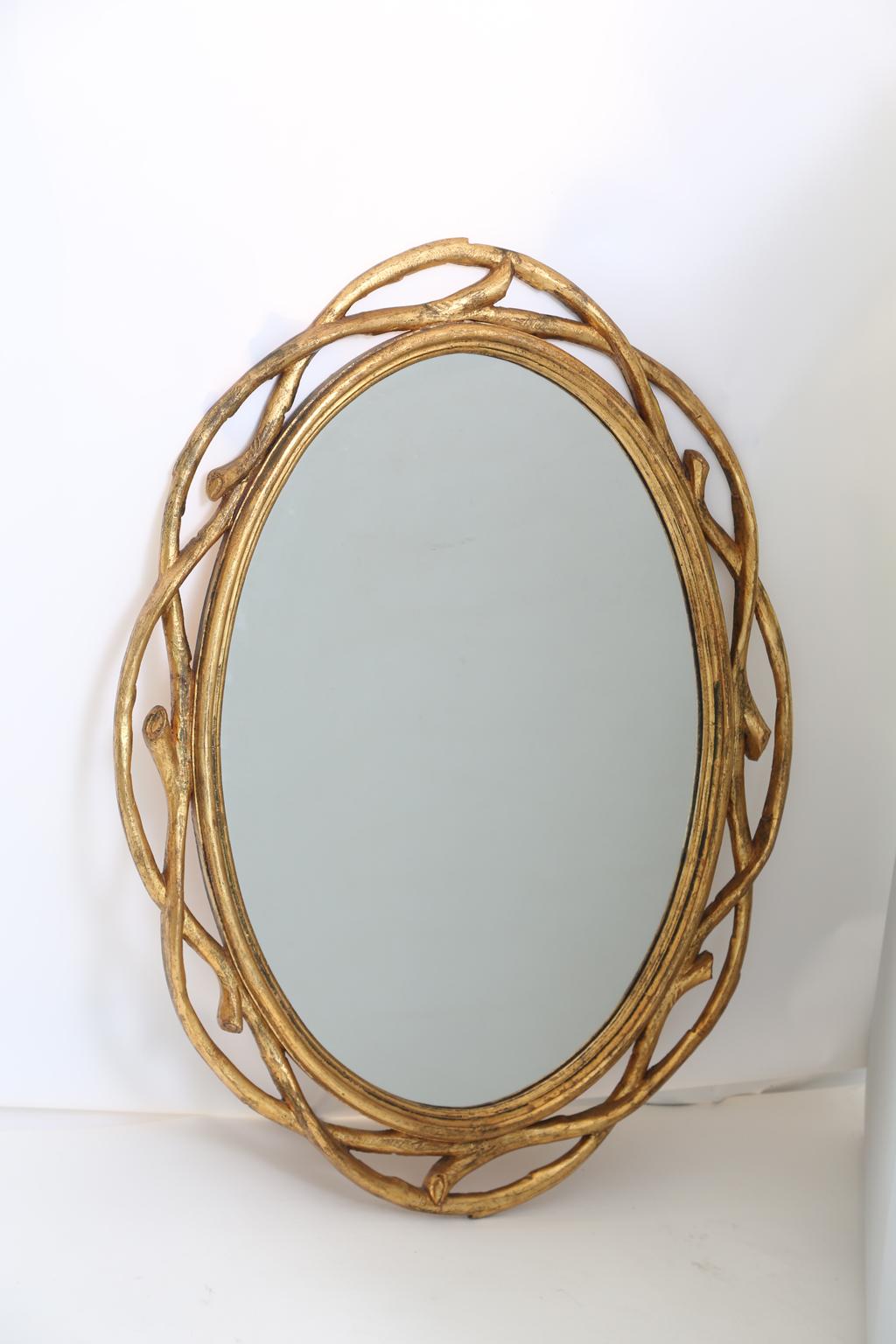 Pair of mirrors, each oval looking glass in a giltwood frame carved as intertwined branches. 

Stock ID: D2503.