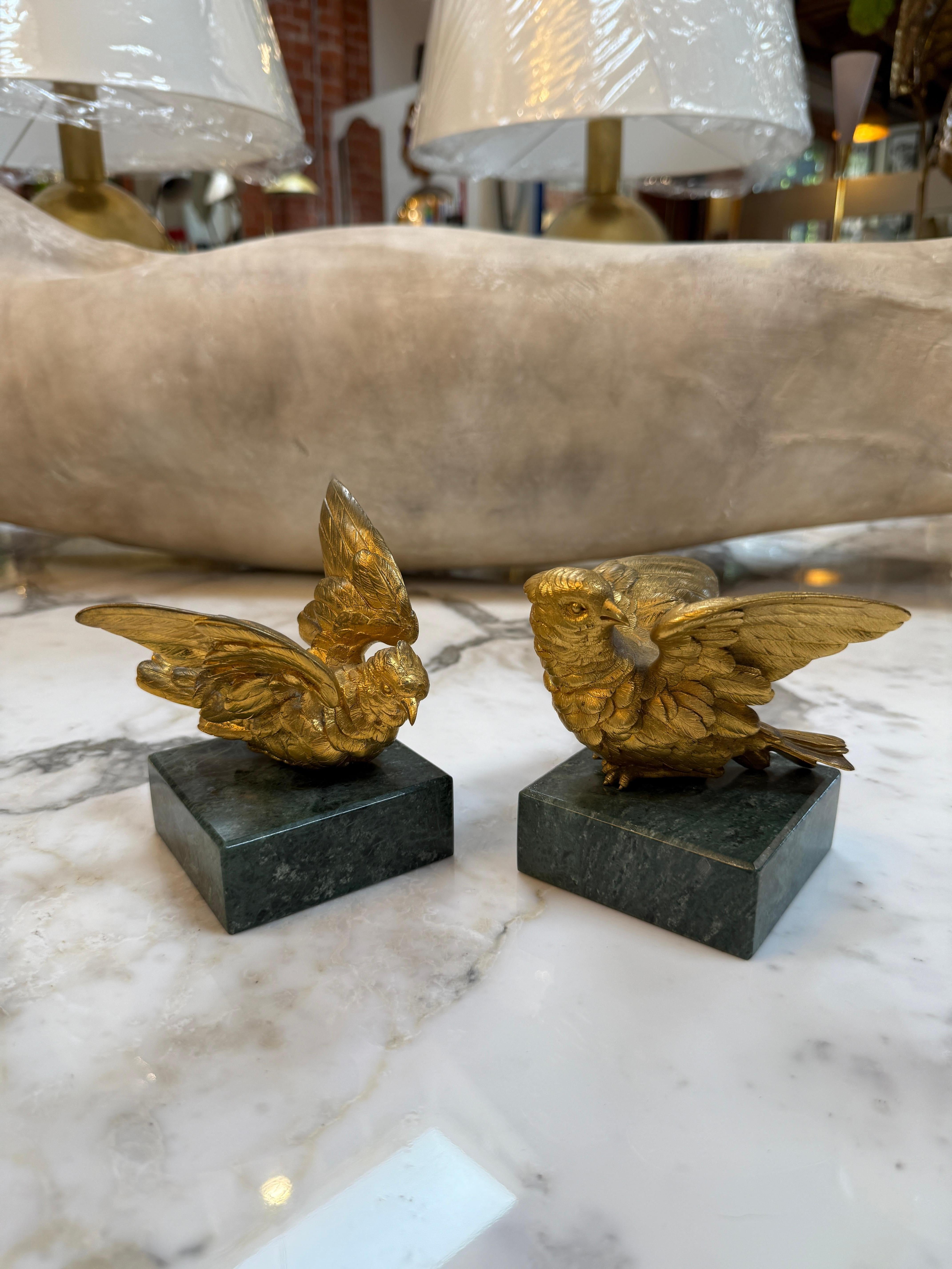 Pareja de esculturas de pájaros de bronce dorado sobre base de mármol Italiano en venta