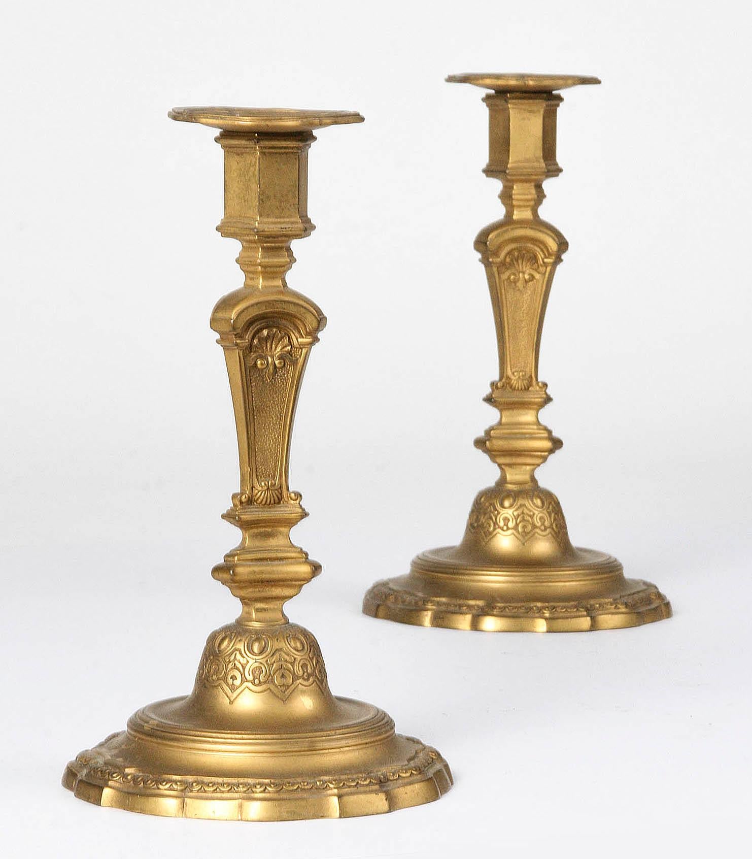 Pair of bronze candlesticks, French Regence style. The candlesticks are made circa 1900. The candlesticks are matte gold and have a beautiful patina because of the original gilding. In good condition.