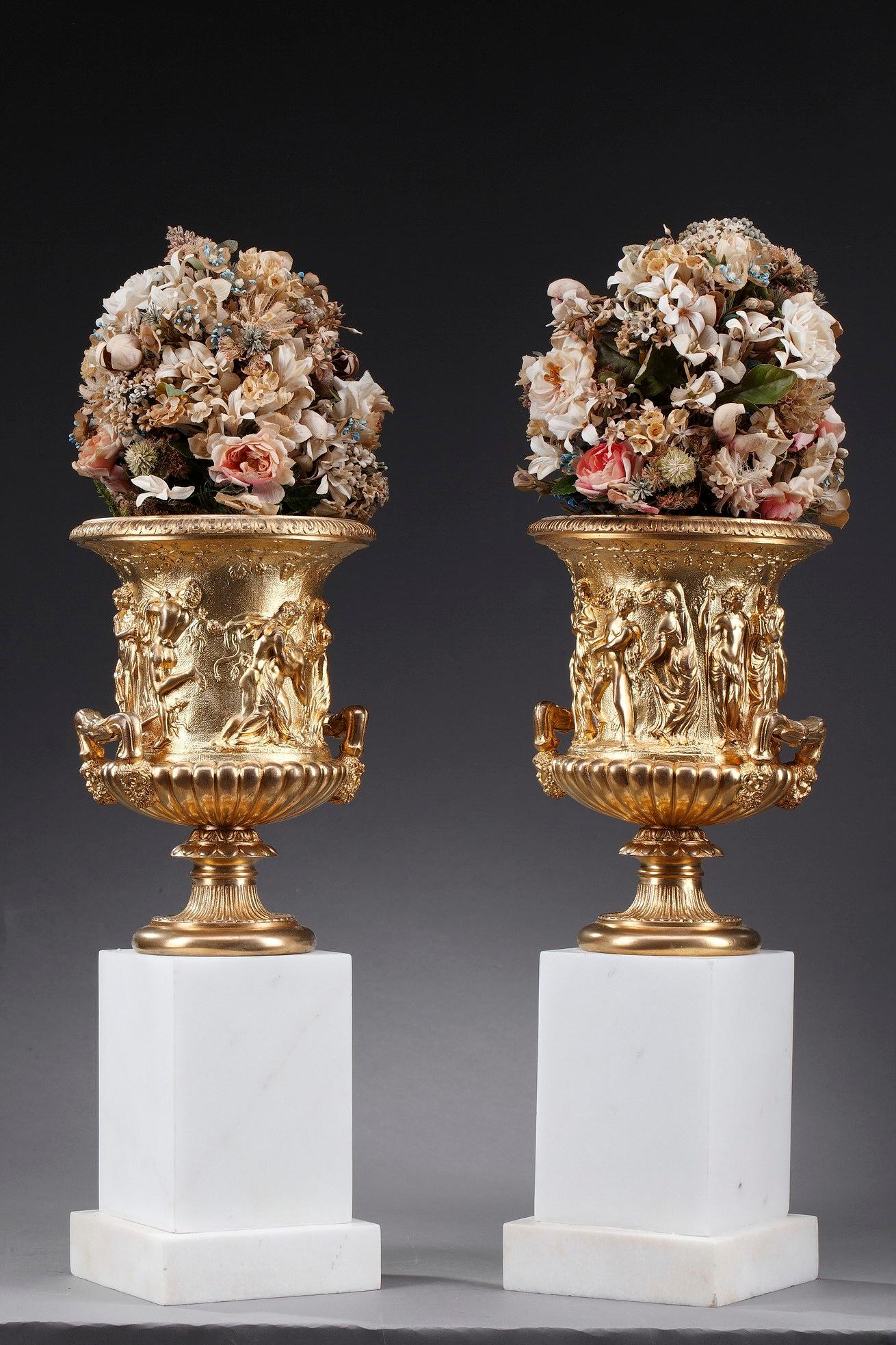 This beautiful pair of ormolu Medici vases depicts a Bacchanalia with young men and women dressed à l'antique, playing and dancing on a matting background adorned with vine branches and grapes. The handles are supported by bearded masks. The