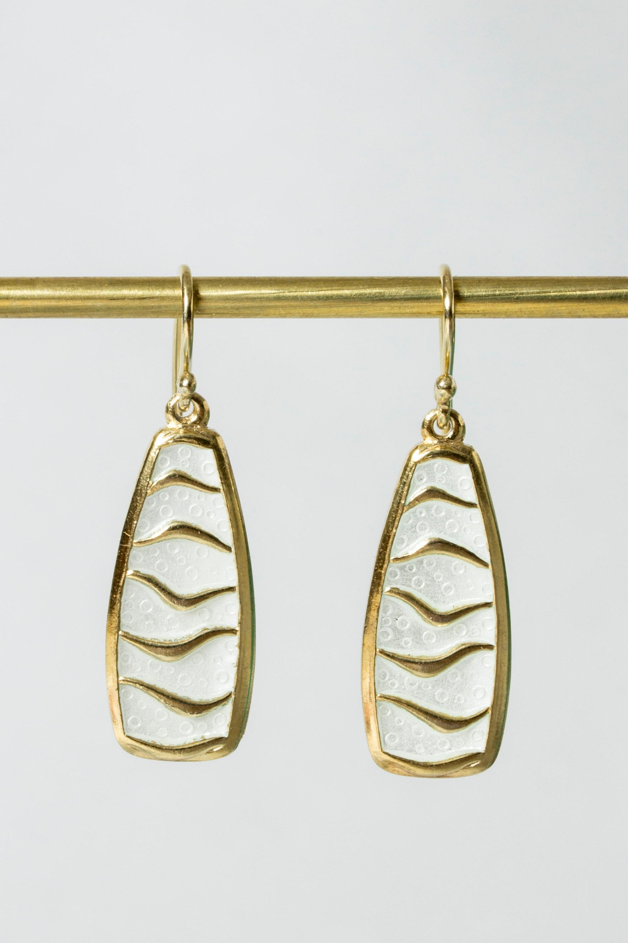 Pair of cool silver earrings from David Andersen. The silver is gilded, which makes an elegant contrast with the white enamel. Graphic pattern, subtle bubbles in the enamel.