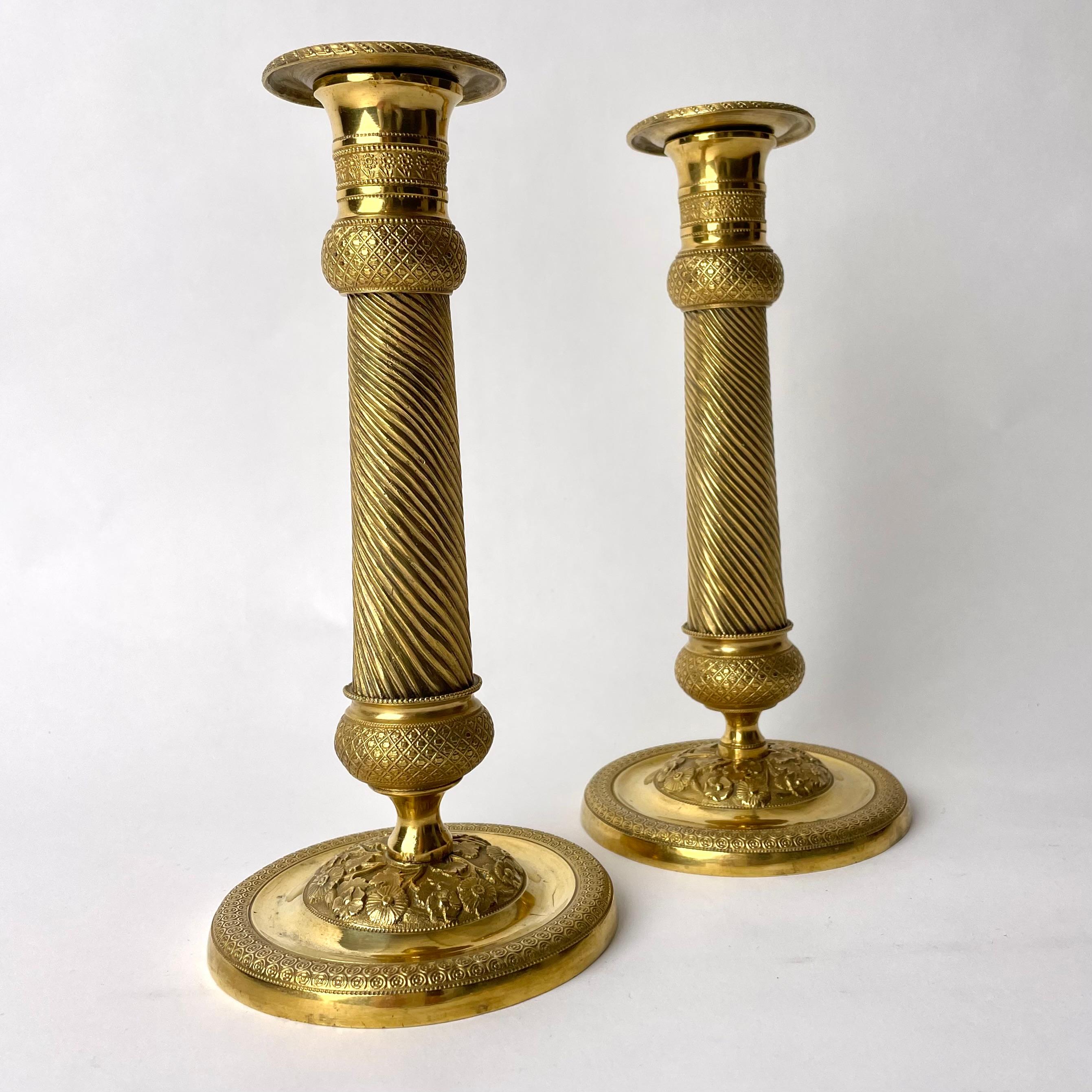 Paar vergoldete französische Empire-Kerzenleuchter mit charmantem Dekor aus den 1820er Jahren (Vergoldet) im Angebot