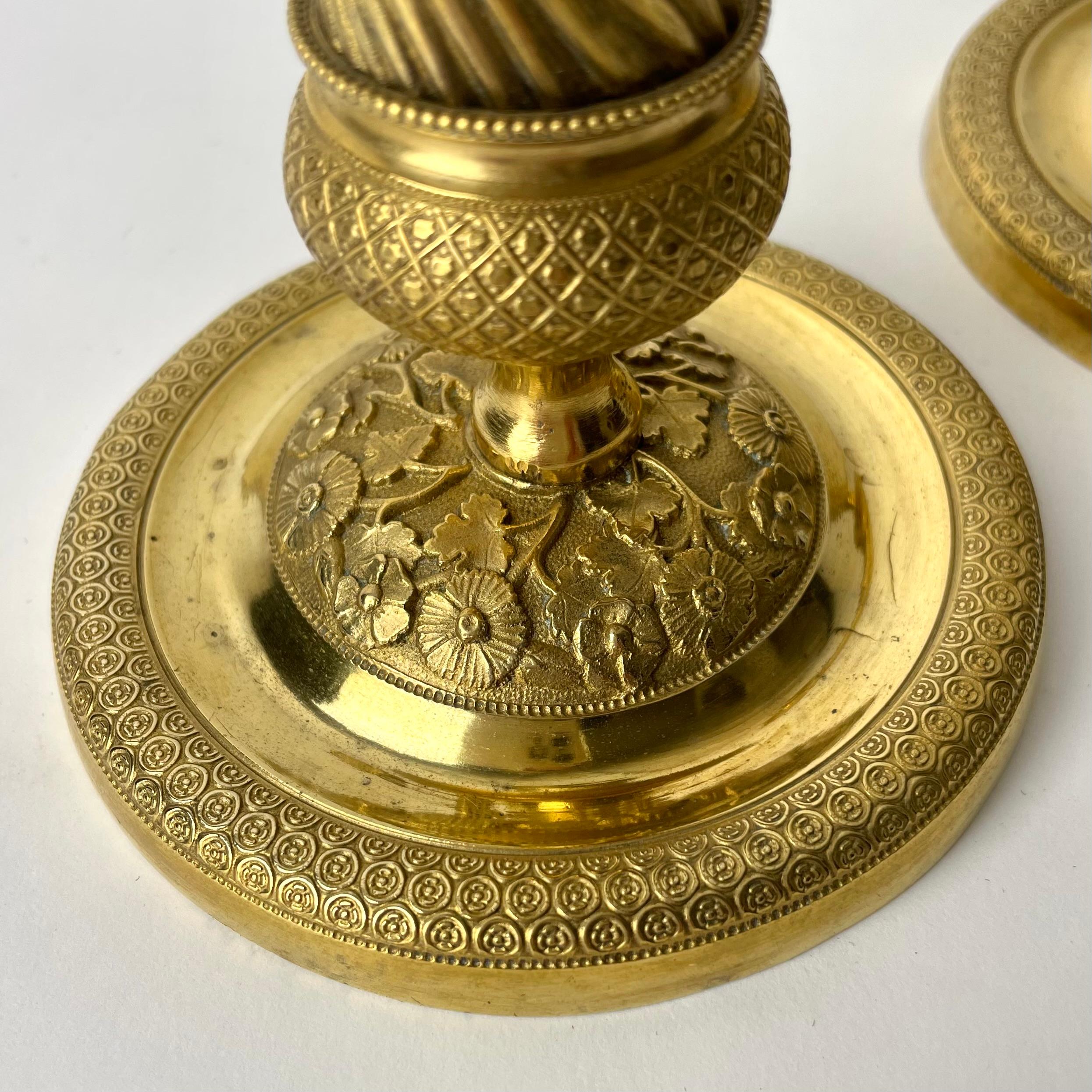 Early 19th Century Pair of Gilded French Empire Candlesticks with charming decor from the 1820s For Sale