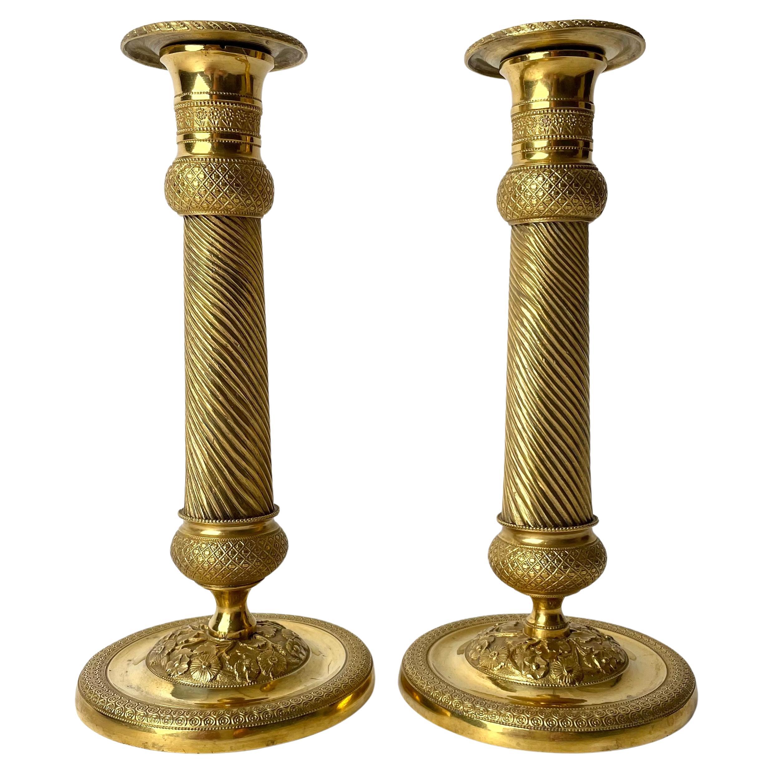 Pair of Gilded French Empire Candlesticks with charming decor from the 1820s For Sale