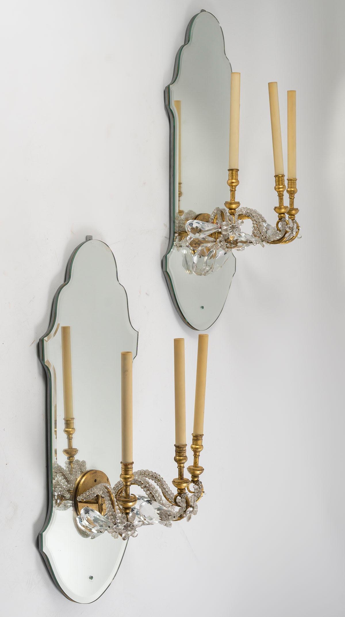 Pair of gilded iron and mirror sconces with glass drops, 1950-1960.

Large pair of sconces by Maison Delisle, 1950-1960, in mirror and gilded iron with glass pendants.
h: 85cm, w: 33cm, d: 30cm