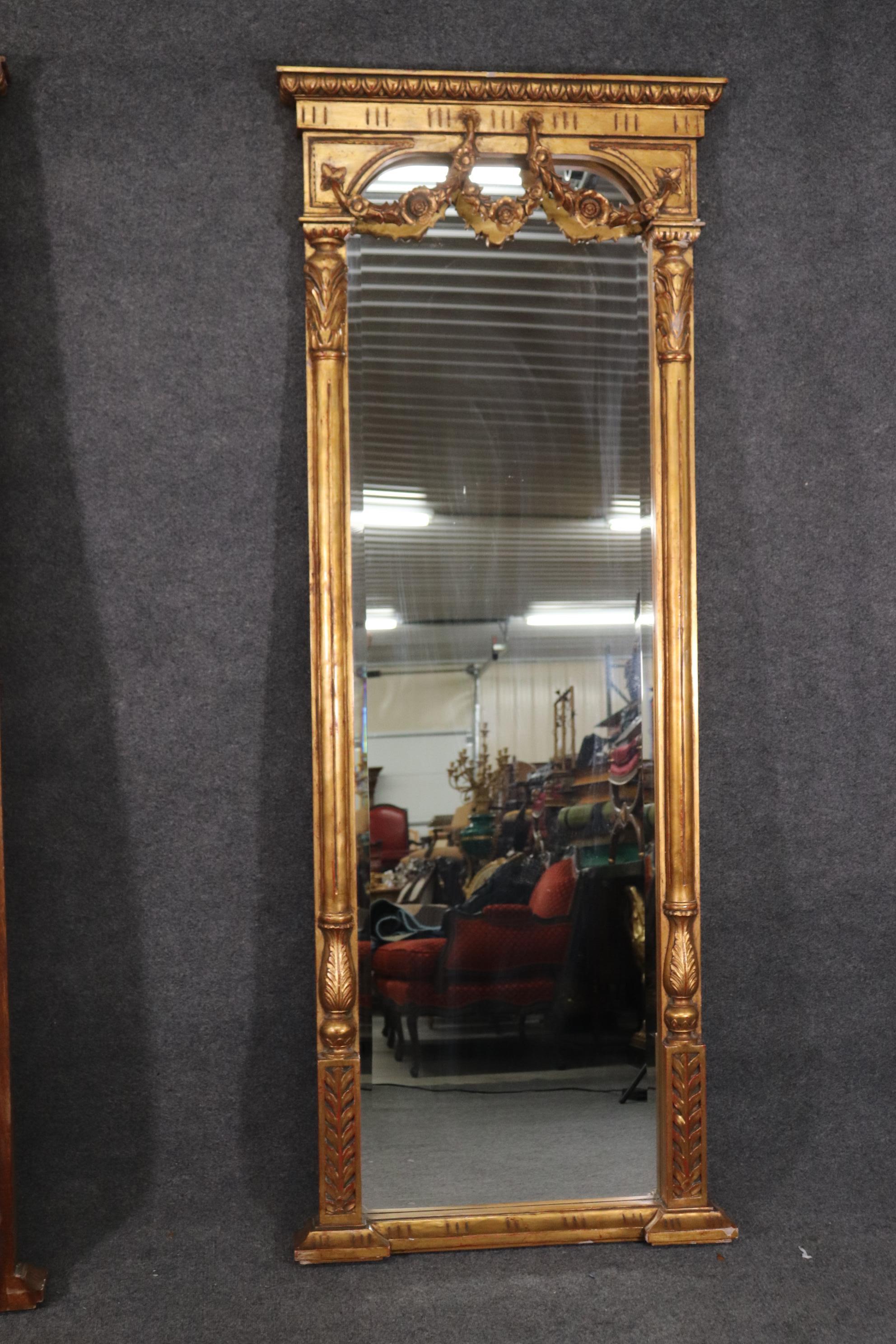 This is a beautiful and rare pair of gold leaf gilded carved Louis XV style pier or hall mirrors. They each measure 84 inches tall x 31.34 wide x 4 inches deep. They are in good condition and have beveled glass mirrors.