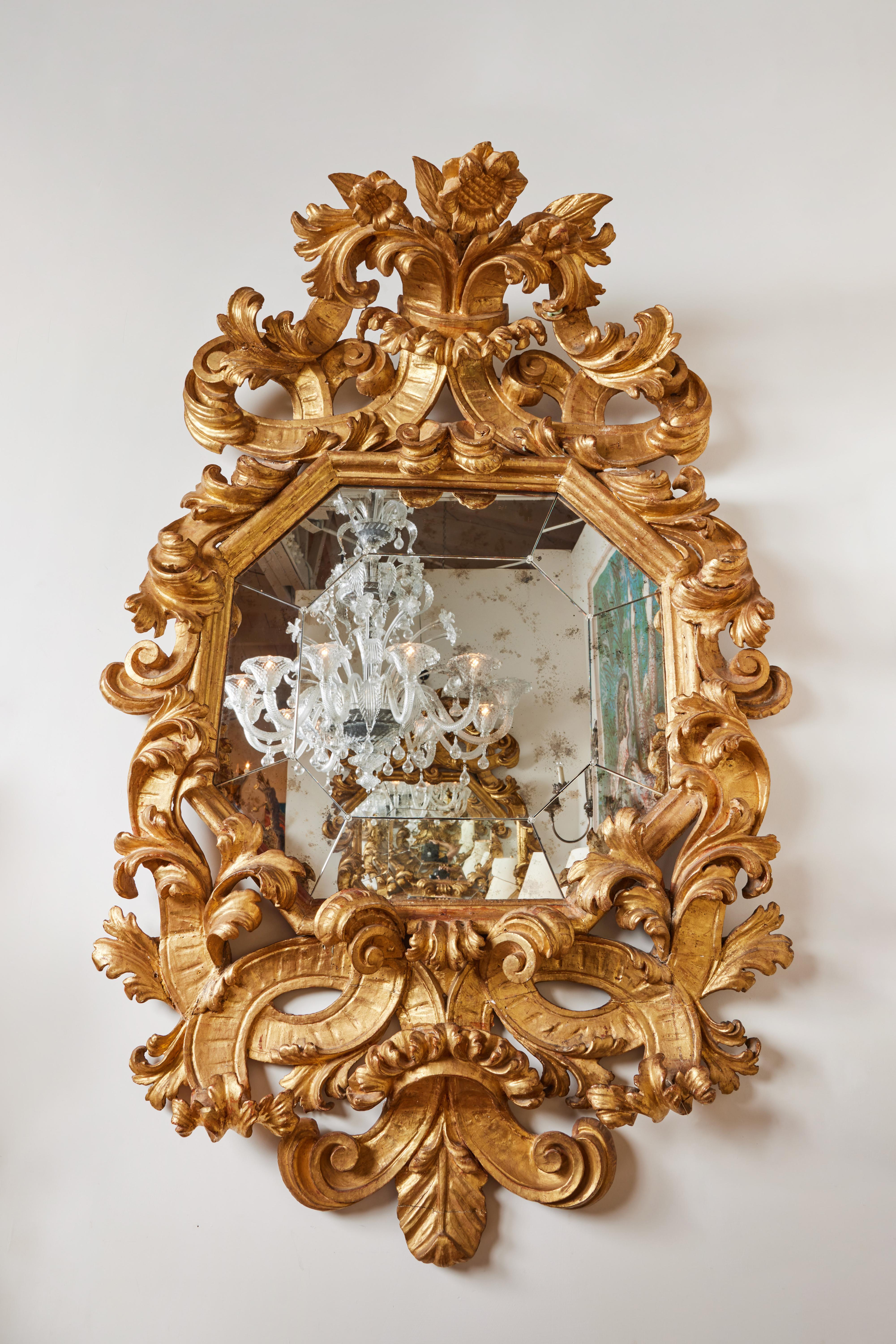 Dramatic pair of hand carved and 22 karat gold gilded Roman mirrors with separately cut mirror to form an octagon. Age appropriate lightly mottled mirror.
 