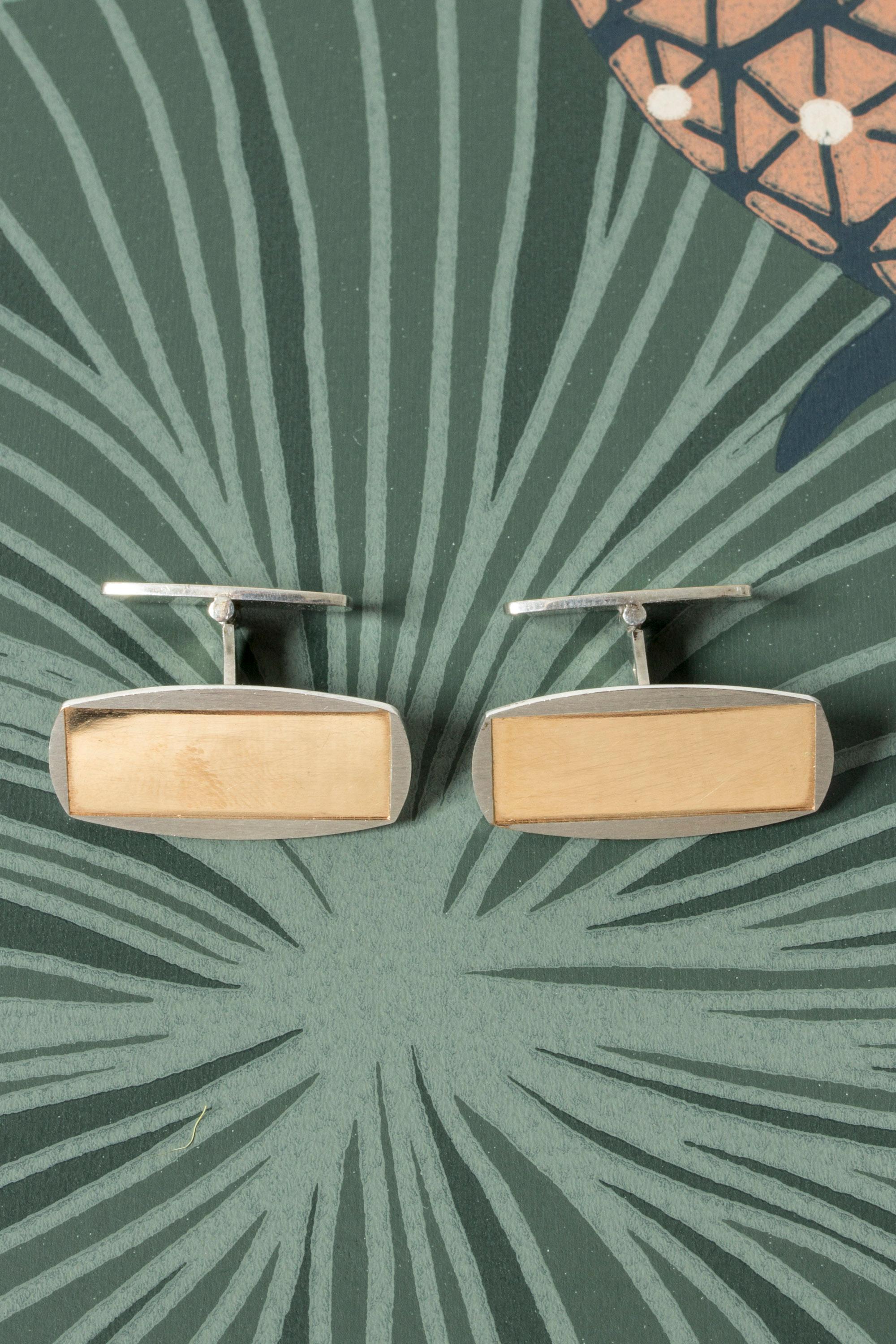 Pair of silver cufflinks from Alton, with a smooth, gilded surface. Elegant, sleek design.
