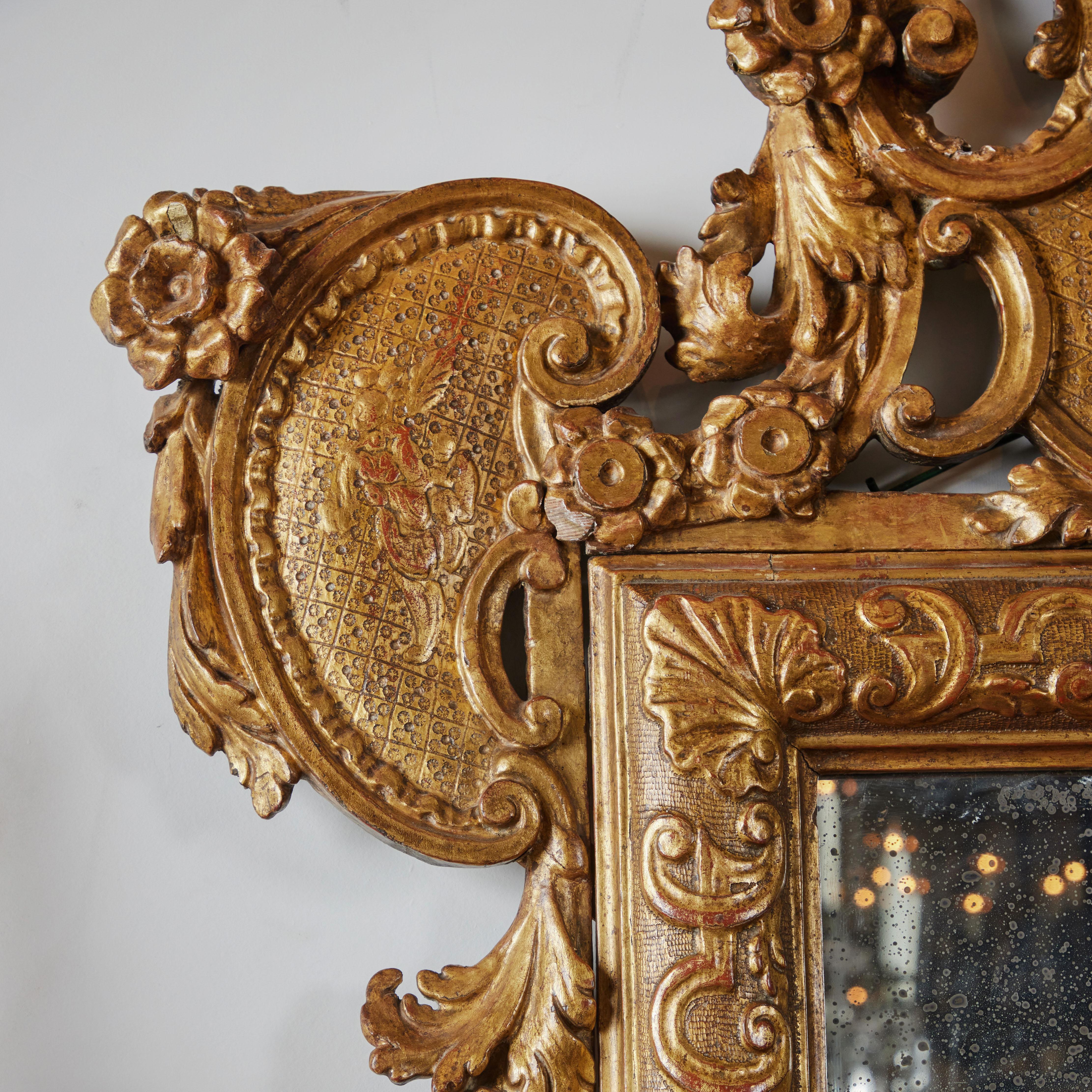 An elegant pair of hand carved and gilded, Venetian mirrors with Chinoiserie and floral designs. Original glass with age-appropriate mottling.  