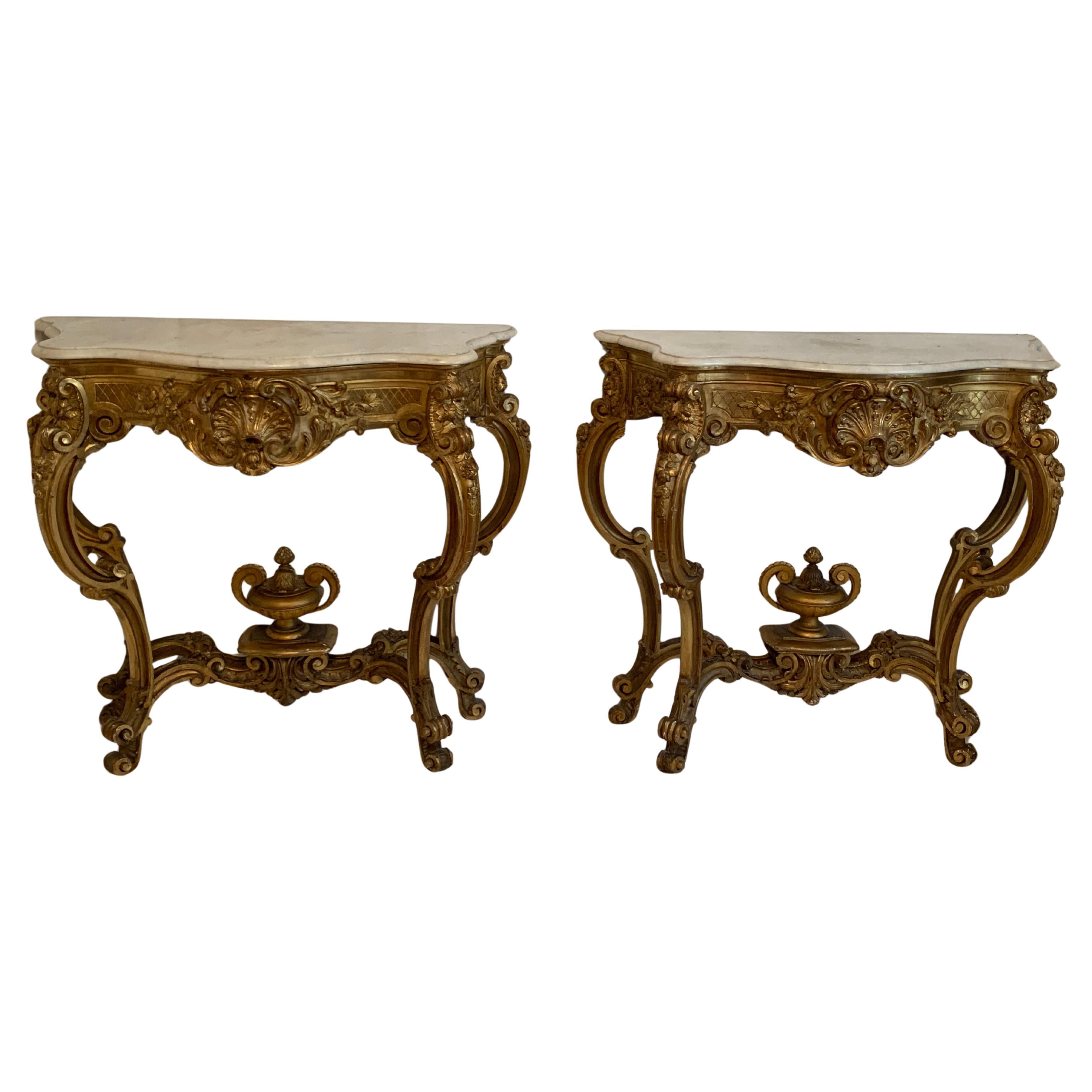 Preciosa pareja de consolas de cuatro patas estilo Luis XV en  madera dorada con tapa de mármol ,la talla en el frontal y los laterales son notables, las cuatro patas están unidas por un separador ,un magnífico corte en el centro da elegancia a este