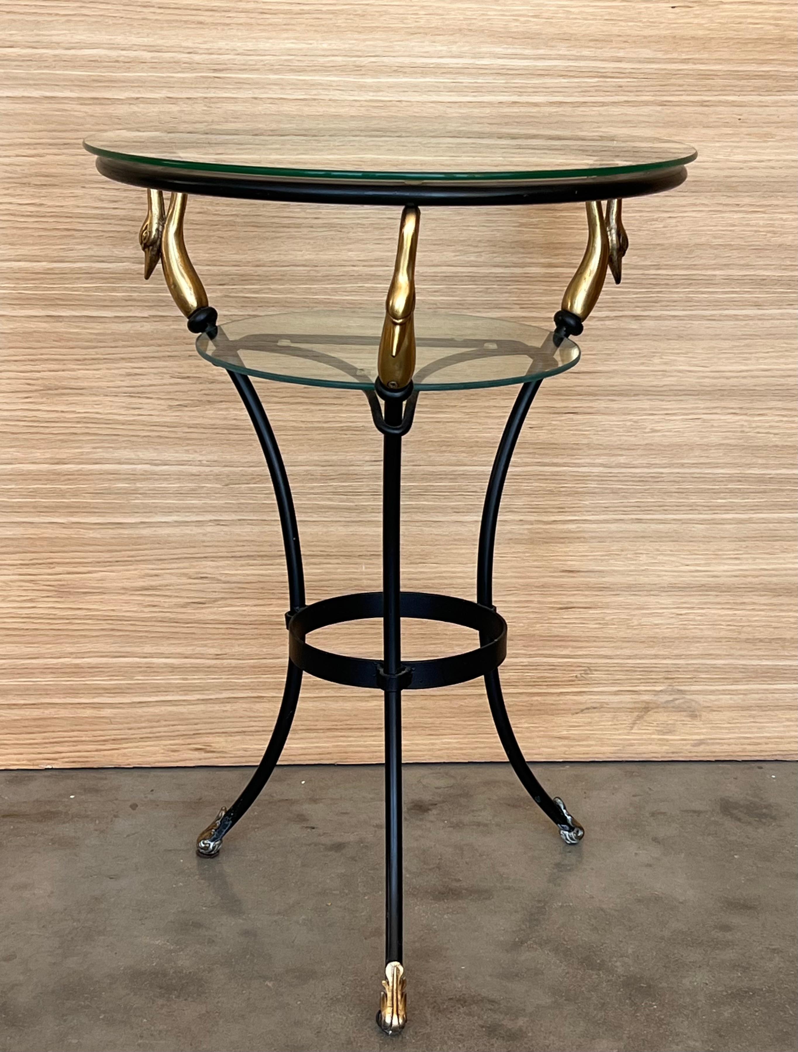 Cette rare table basse en forme de cygne de style Empire français des années 1920 est faite de fer forgé avec des accents dorés. Très lourd et robuste, avec des plateaux en verre à deux niveaux. Bon état vintage avec une usure cosmétique normale due