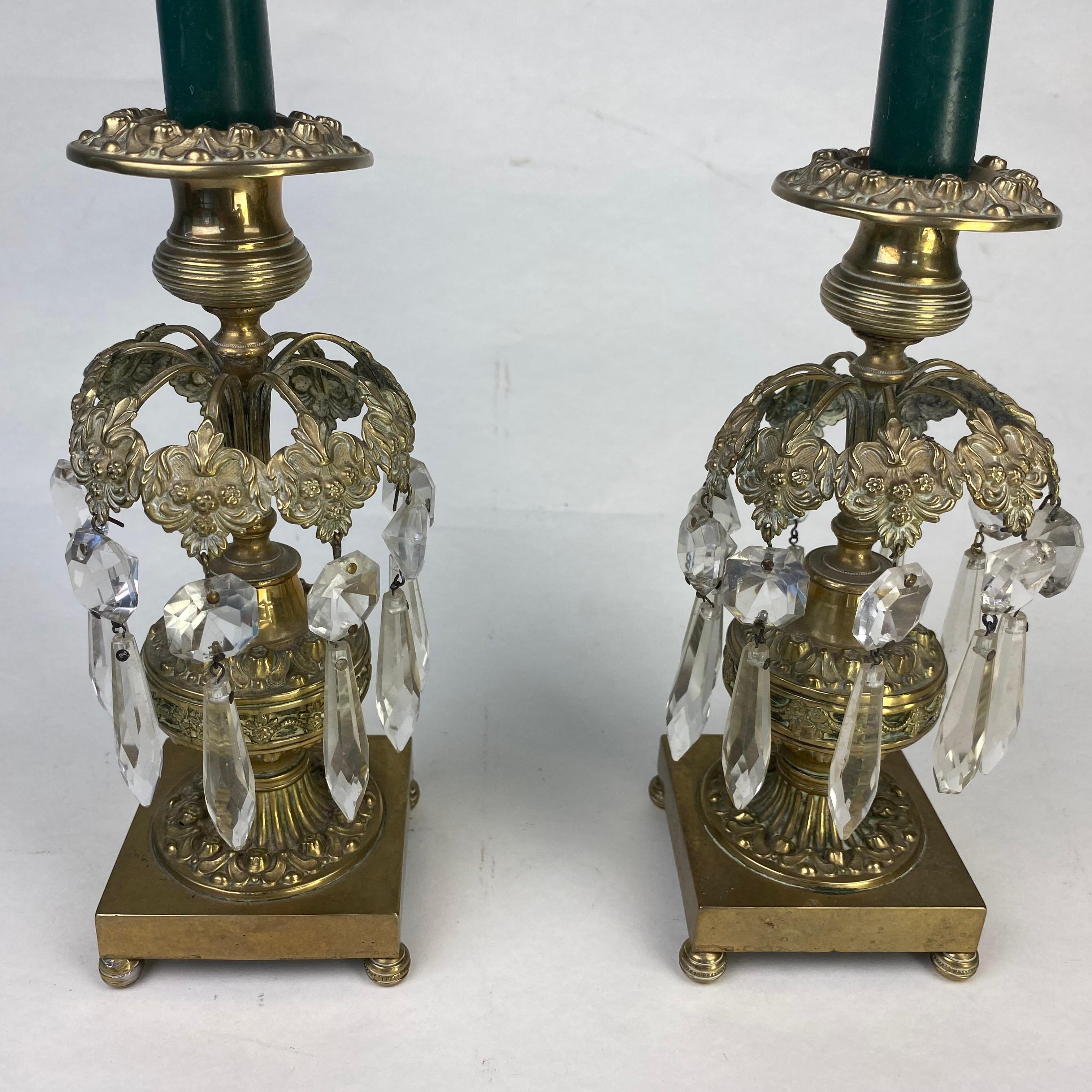 A good pair of gilt metal candleticks with prism-cut glass drops.  