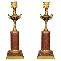 Pareja de candeleros de bronce dorado y patinado y mármol rojizo, hacia 1820