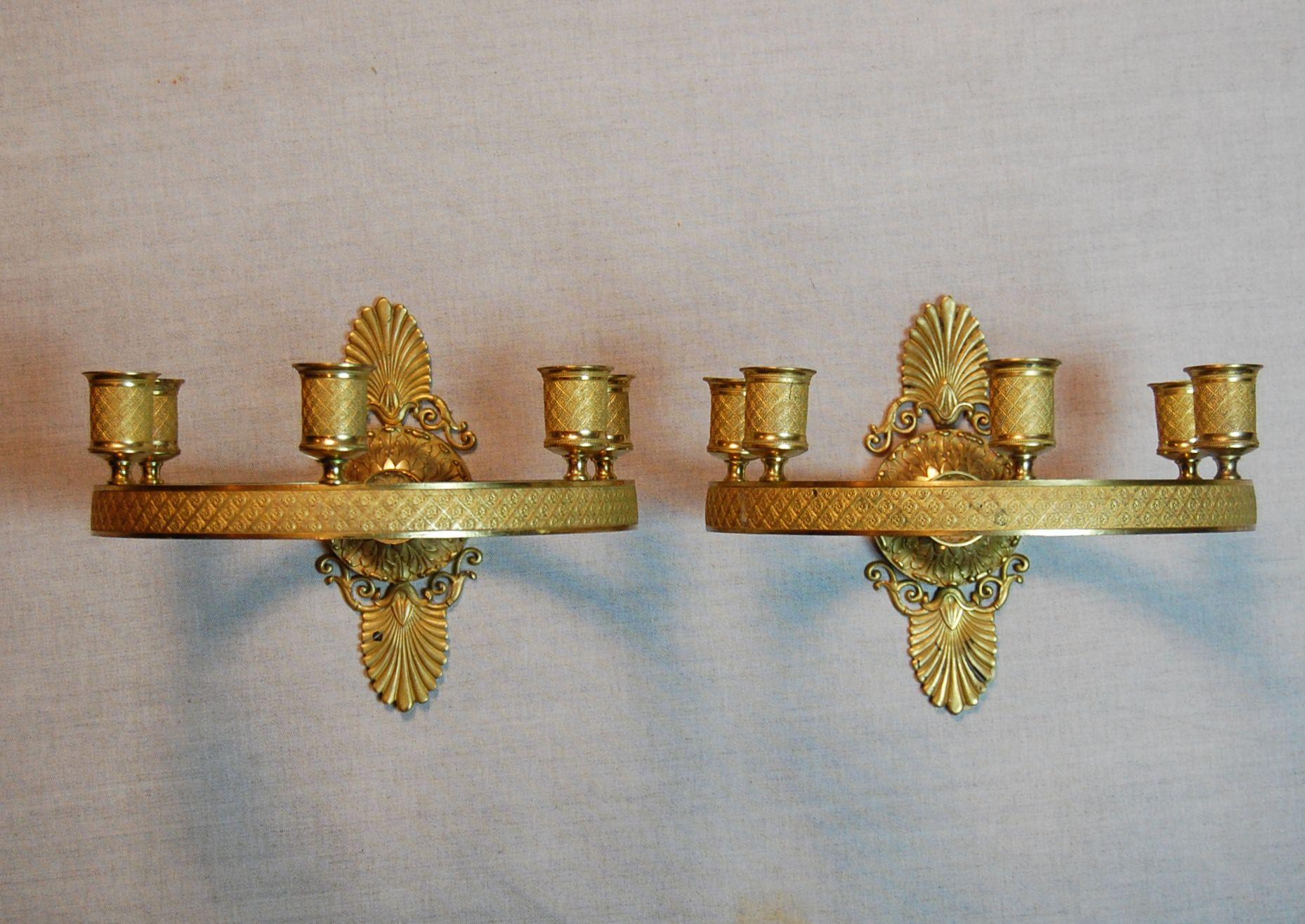 A pair of gilt brass (possibly bronze) Charles X wall sconces in excellent condition, and in a rare circular form with five lights. Heavily chased and etched candle cups and rings, these are a beauty.