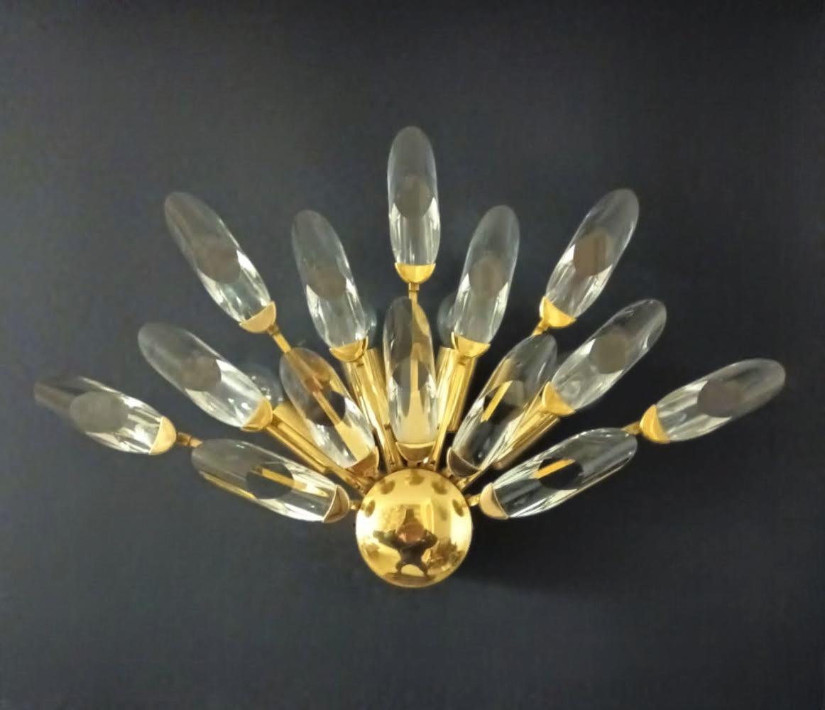Italienische Wandleuchte mit 14 geschliffenen Kristallen, die auf einer vergoldeten Messingstruktur montiert sind und ein halbes Sonnenschliffmuster bilden, entworfen von Oscar Torlasco für Stilkronen / Made in Italy, um 1970
Originalstempel auf dem