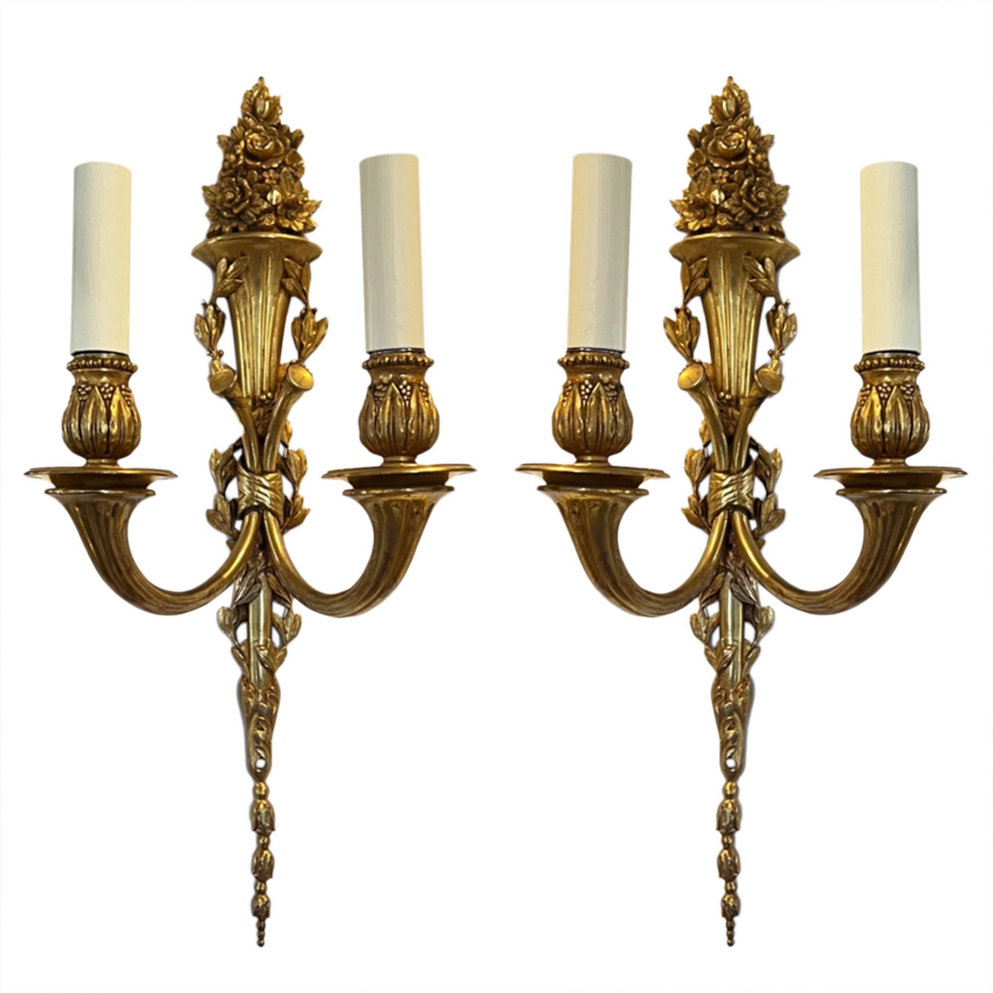 We have two pairs of these stunning gilt brass wall sconces.

Exceptional quality and with a decorative design. Please take a close look at all our photographs. 

Made in France in the 1950s. 

One pair is slightly larger than the other, however,