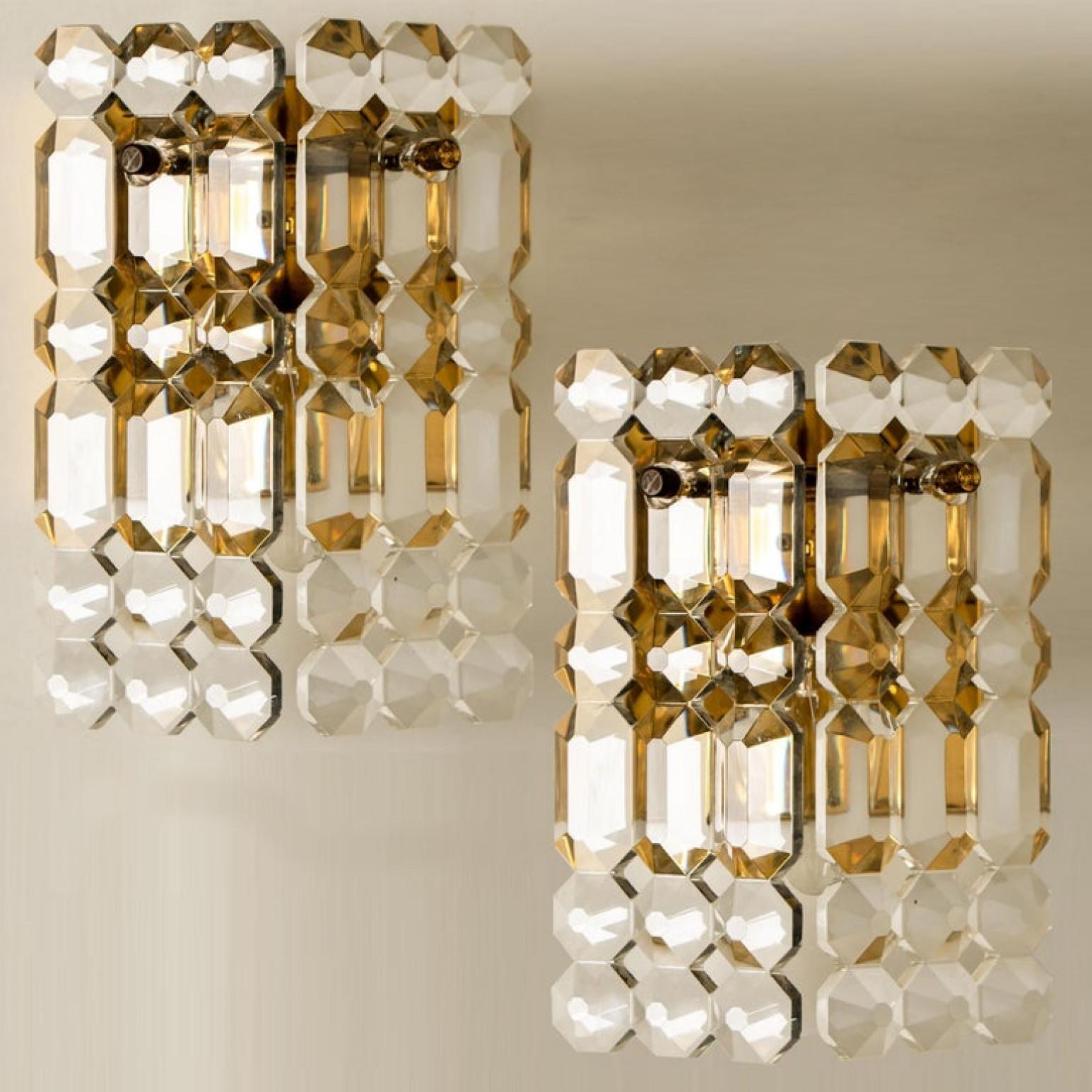 Luxurious pair of gold-plated frames and thick crystal sconces by the famed maker, Kinkeldey. One-light source. Very elegant light fixtures, comfortable with all decor periods. The crystals are meticulously cut in such a way that radiate the light