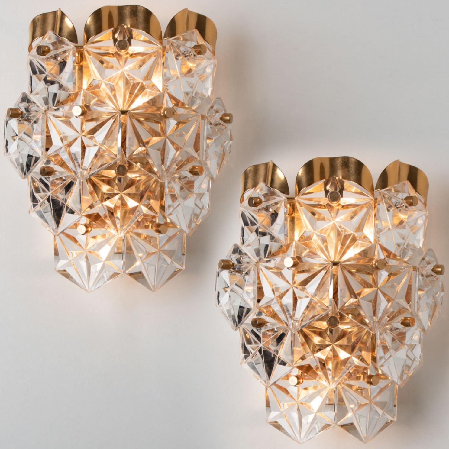 A luxurious pair of gold-plated frames and thick diamond crystal sconces by the famed maker, Kinkeldey. Made in Germany around 1970. (late 1960s, early 1970s)
Two light sources. Very elegant light fixtures, comfortable with all decor periods. The