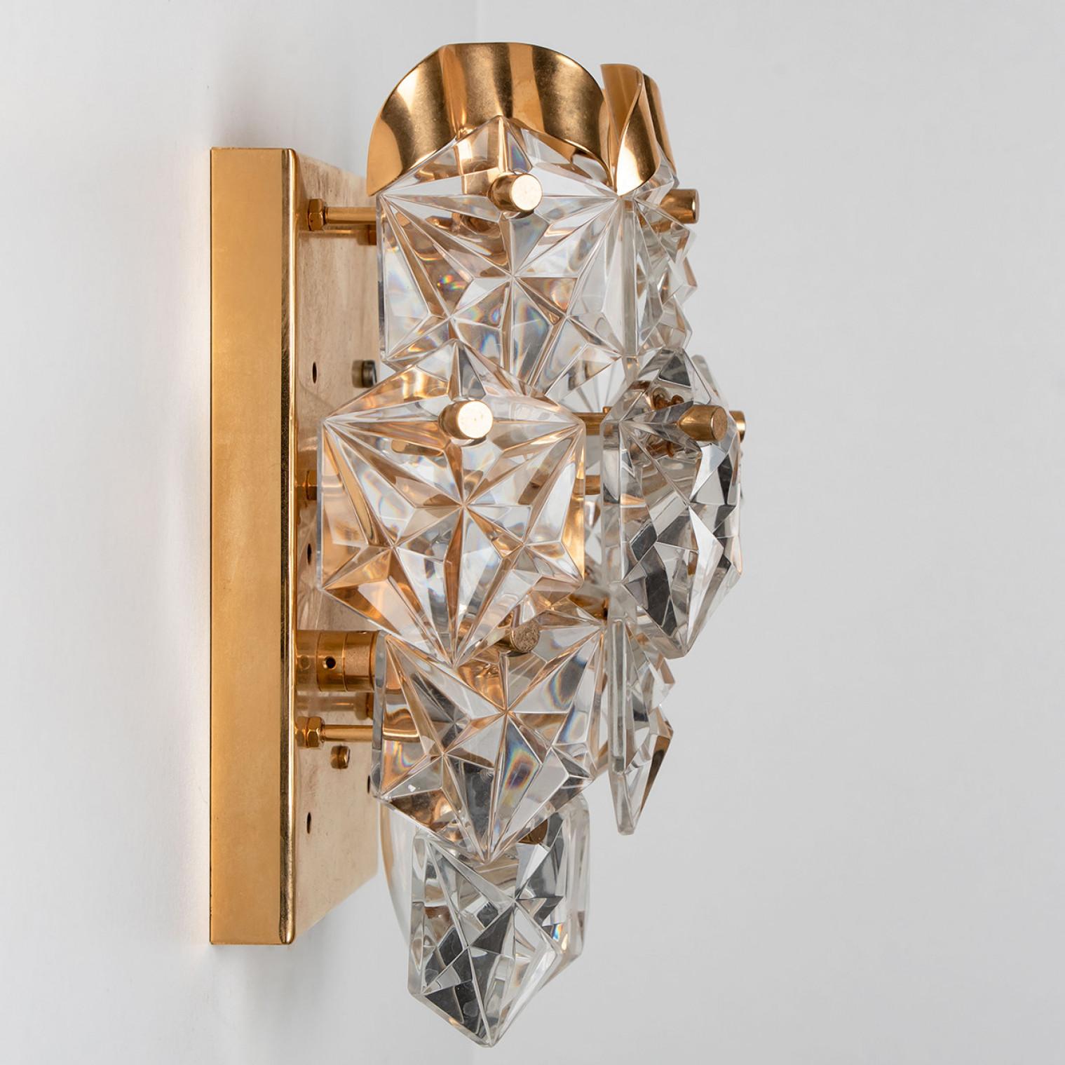 A luxurious pair of gold-plated frames and thick diamond crystal sconces by the famed maker, Kinkeldey. Made in Germany around 1970. (late 1960s, early 1970s)
Two light sources. Very elegant light fixtures, comfortable with all decor periods. The
