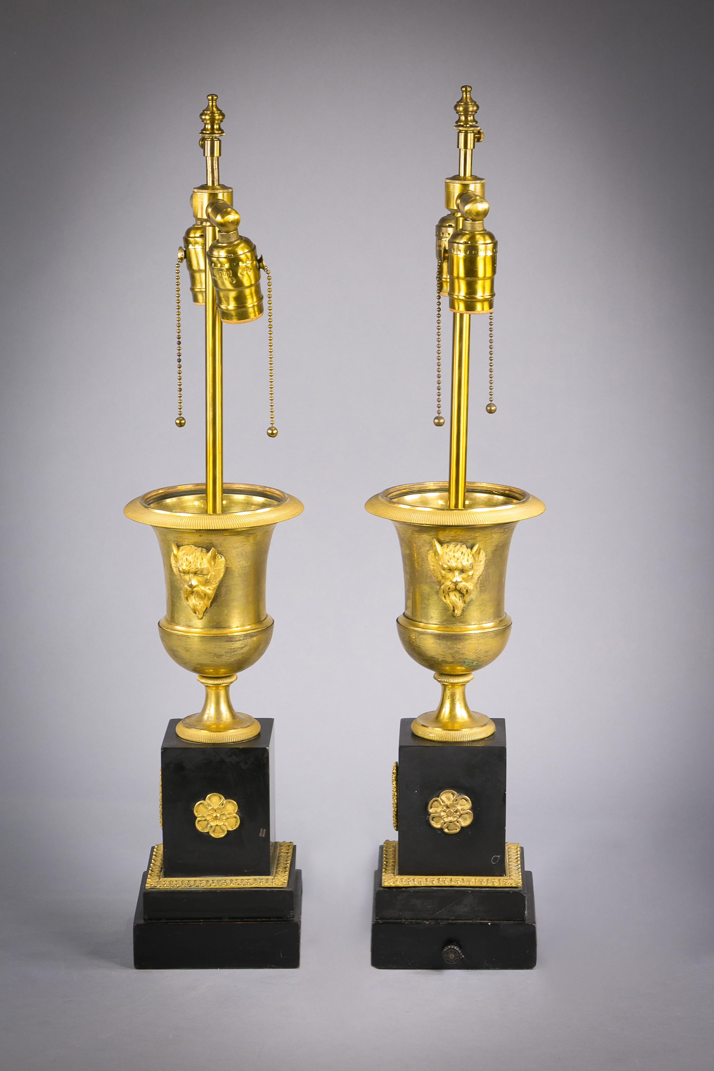 Coppia di lampade in bronzo dorato e marmo nero, 1840 circa.