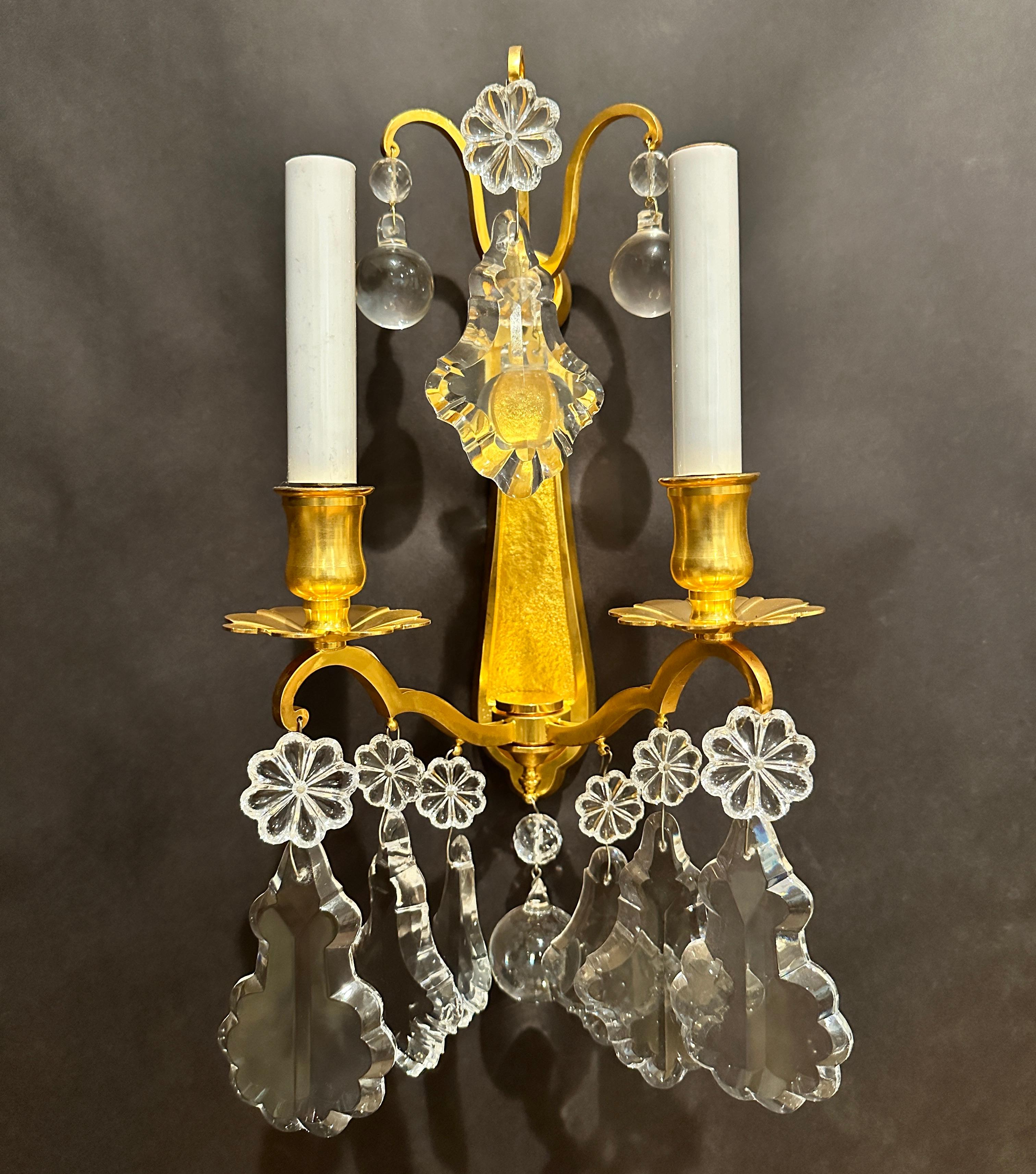 Pareja de apliques de pared de bronce dorado y cristal de dos brazos de estilo Luis XV francés. Alta calidad con un elegante aire clásico.