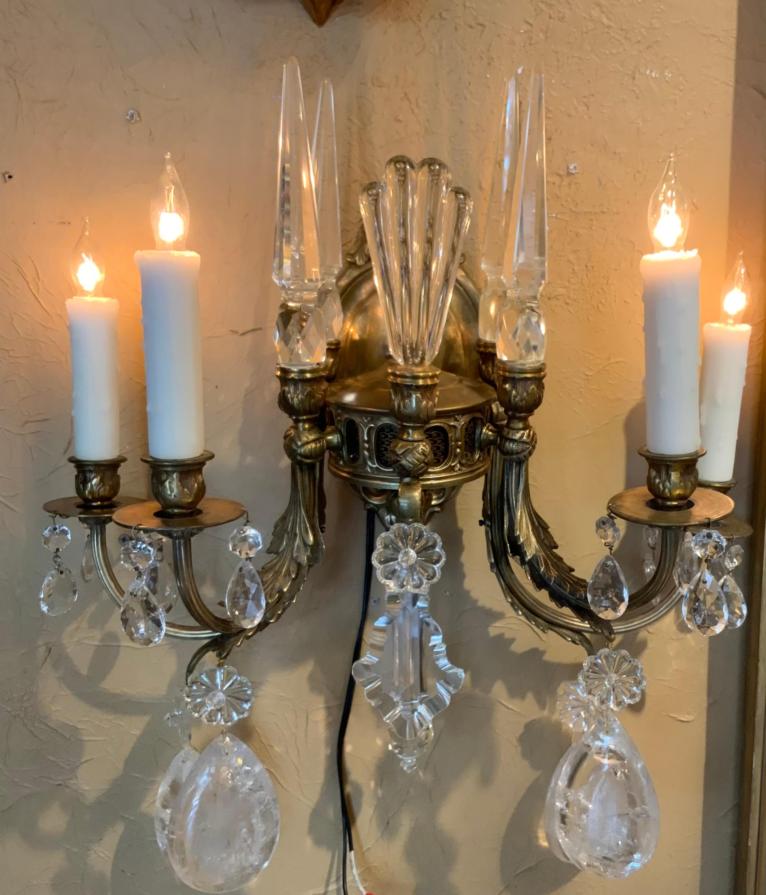 Scrolling arms in bronze with four lights each with both
Rock crystal and clear crystal make these sconces desirable.
The size and shape make this pair special the bronze work
Is well cast and the hue of the gold is very soft in a 
Antique original